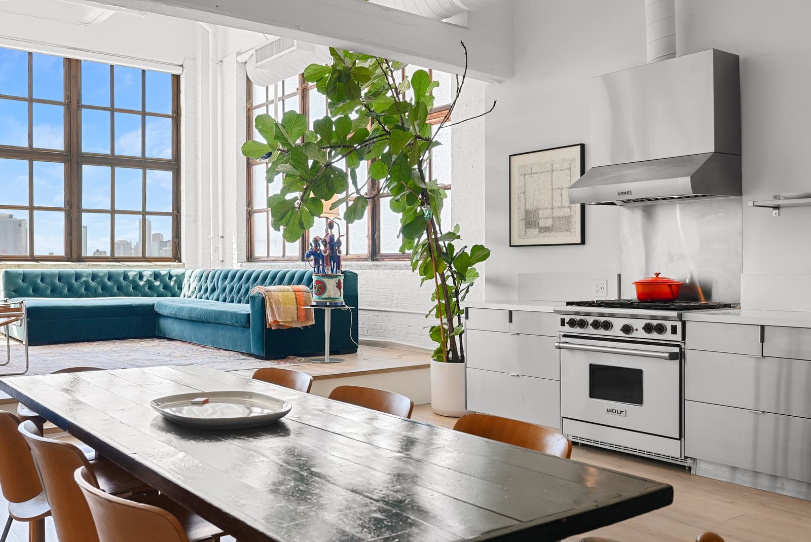 Loft dining table, white kitchen and a fiddle-leaf fig, Arts District