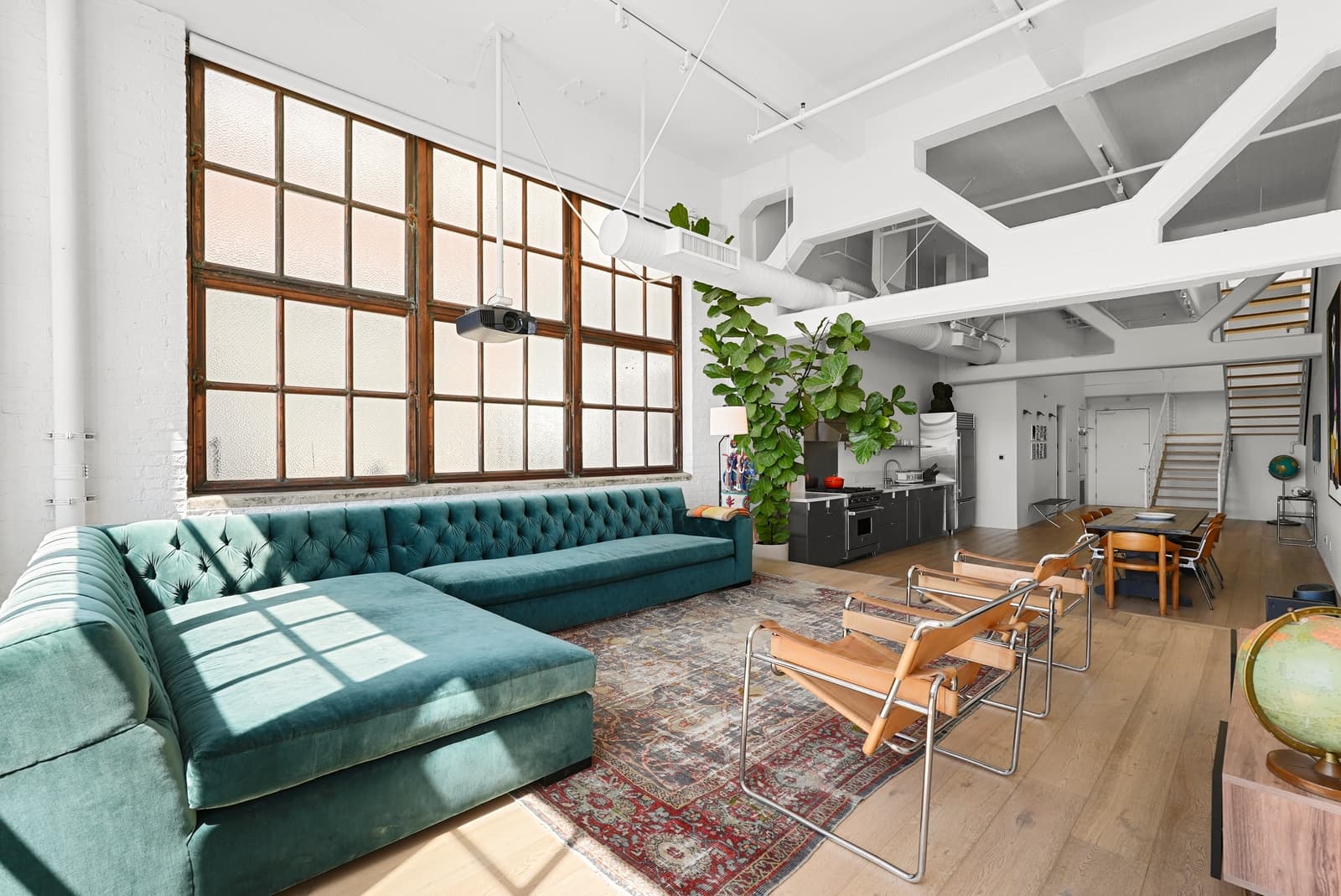 Arts District loft with a green velvet sectional and factory windows