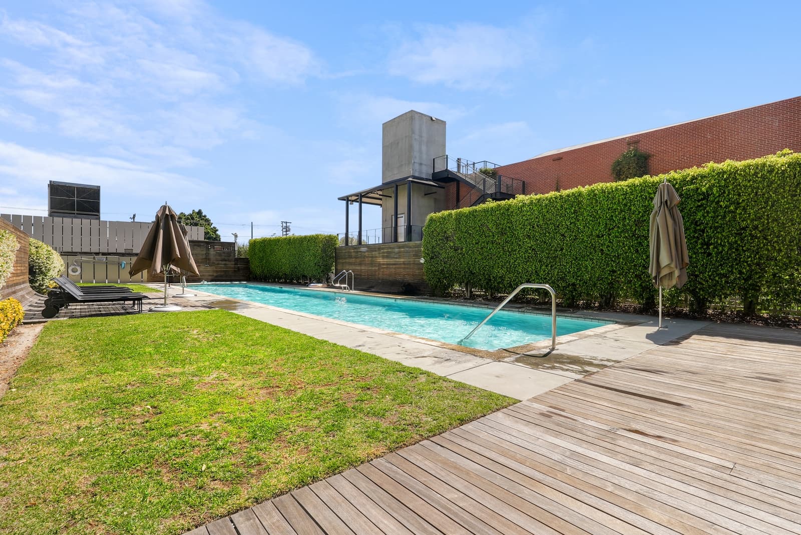 An Arts District rooftop with a pool and a stretch of lawn.