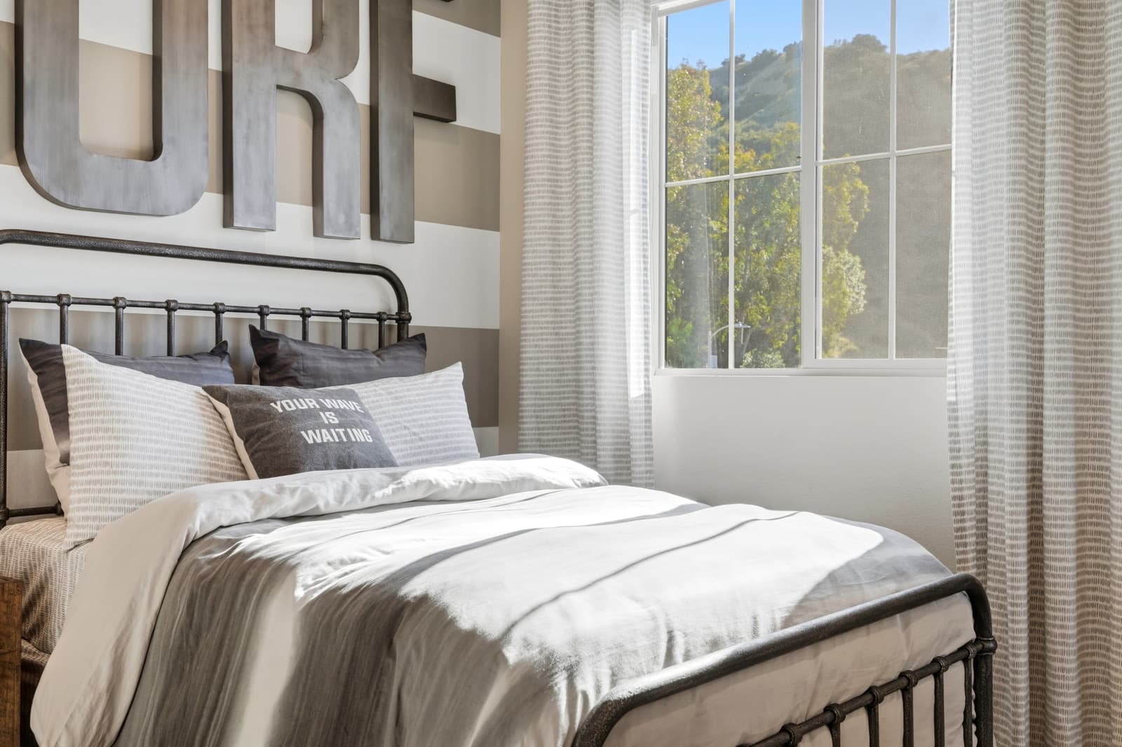 Bedroom with an iron bed frame and soft window light