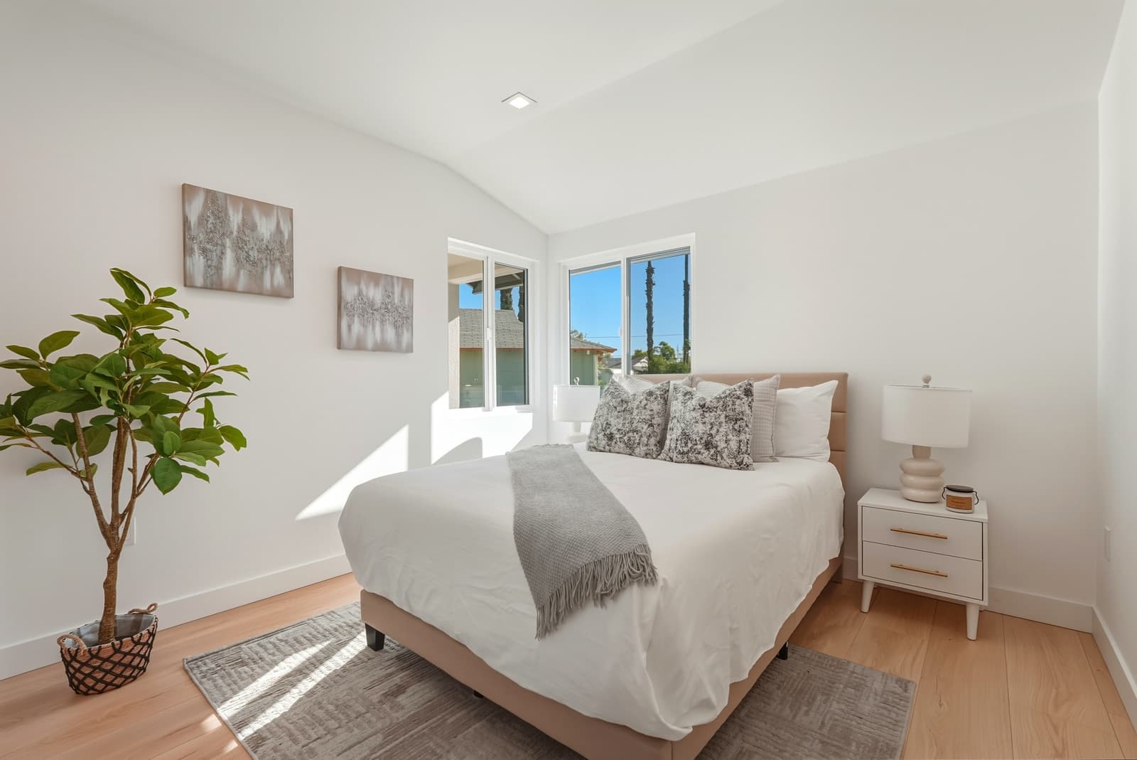 Bedroom with a vaulted ceiling and a fiddle-leaf fig