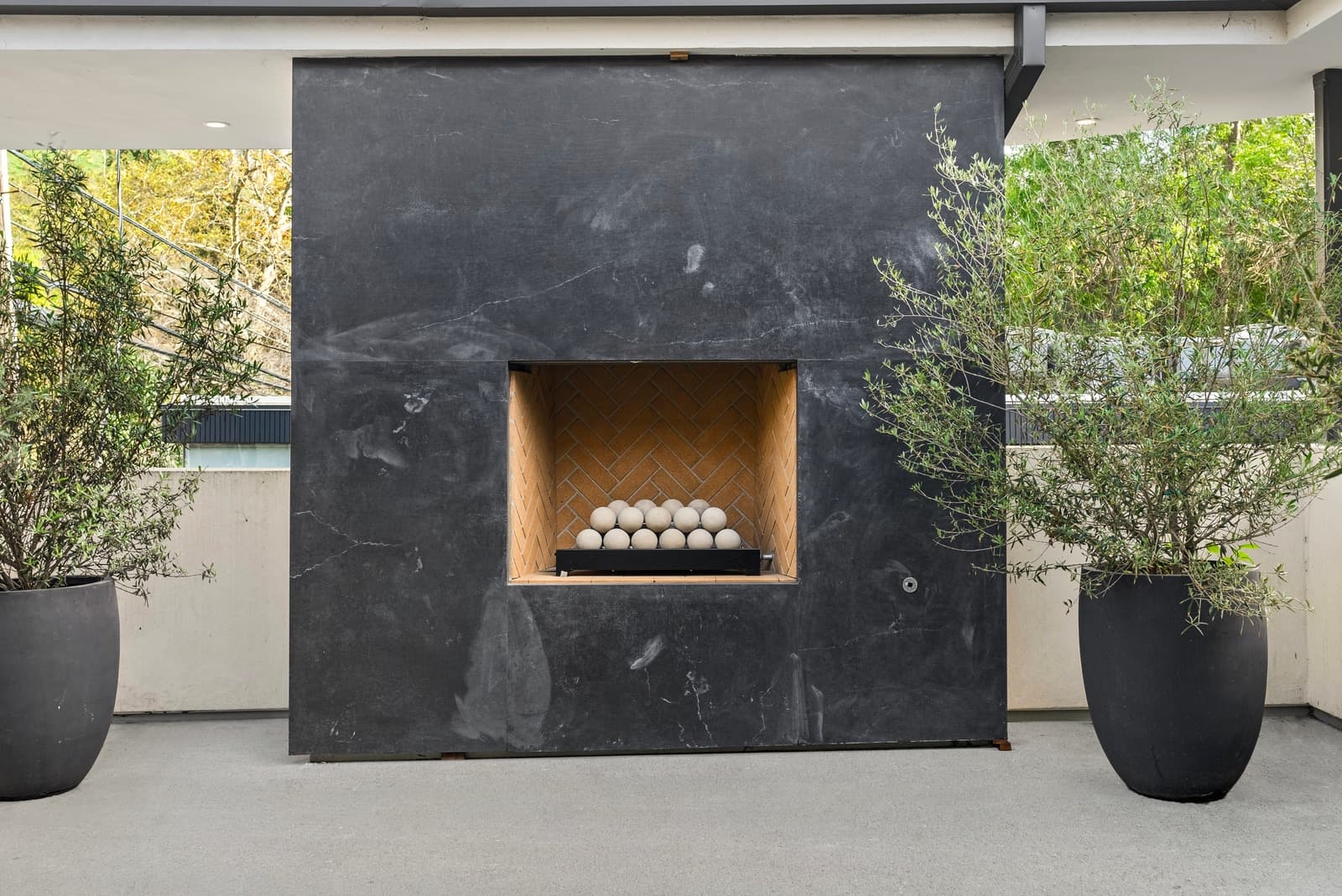 Black stone outdoor fireplace on a covered patio, Beverly Hills