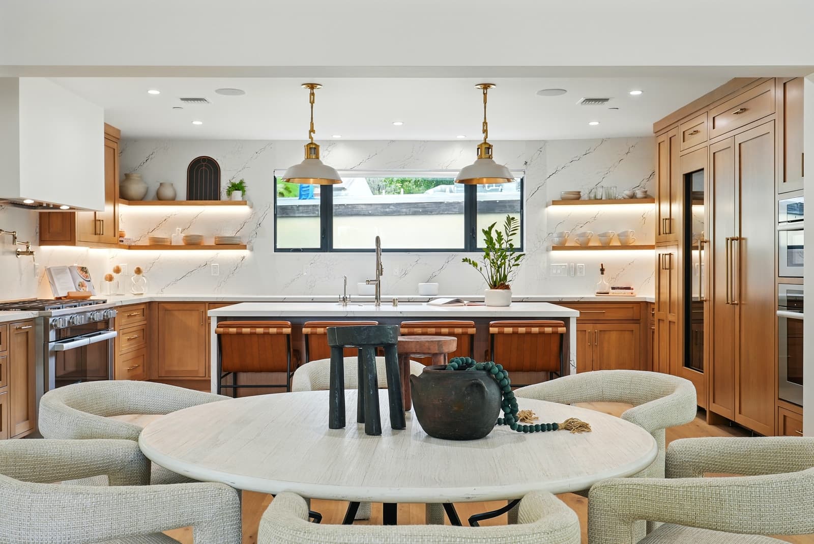 Oak kitchen with a brass range hood and marble island, Beverly Hills