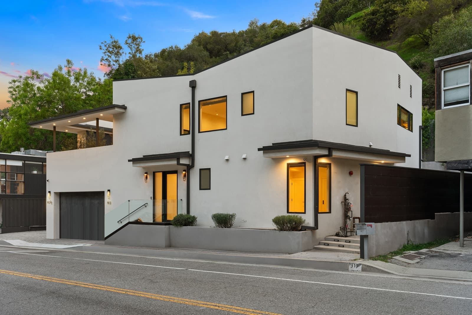 Rear of a Beverly Hills modern at twilight behind a tall hedge