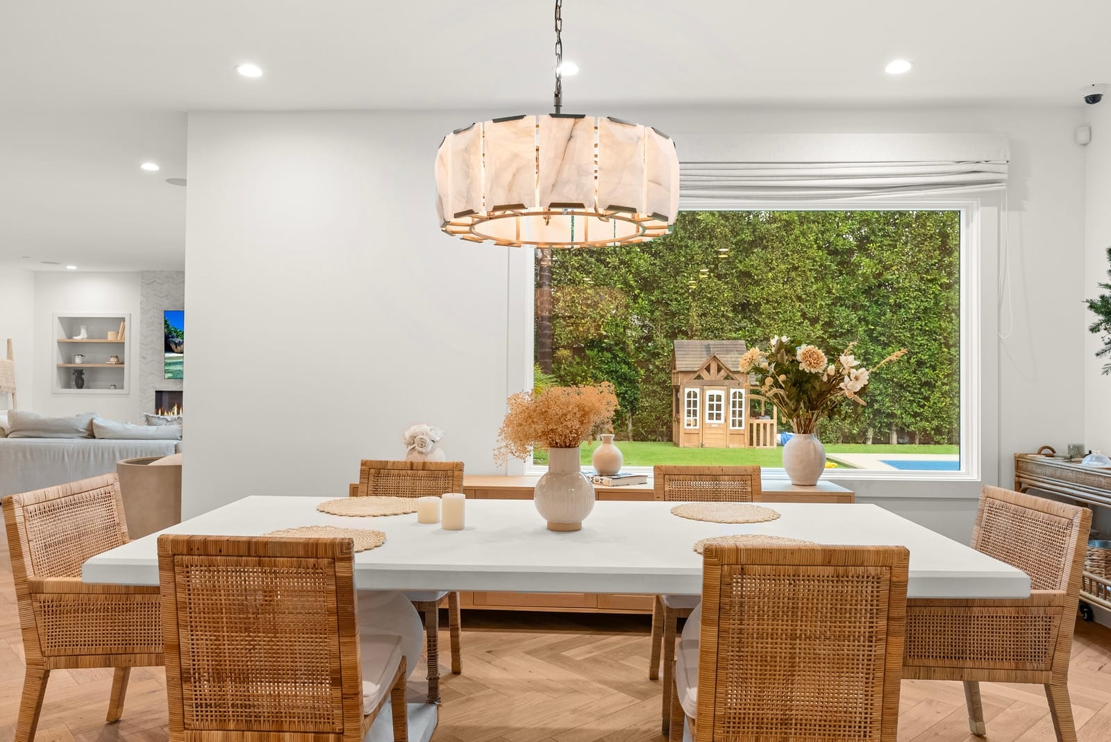 Dining table under a lantern pendant, garden in the window