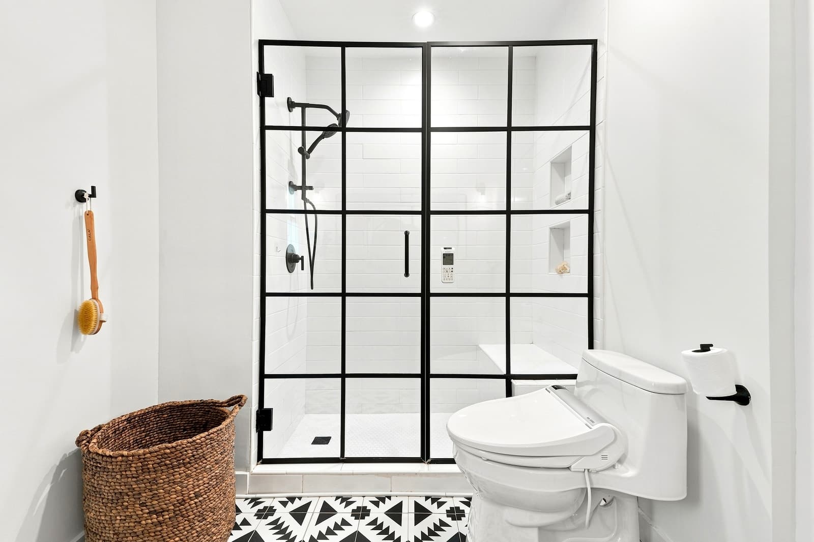 White bathroom with a black steel-grid shower enclosure