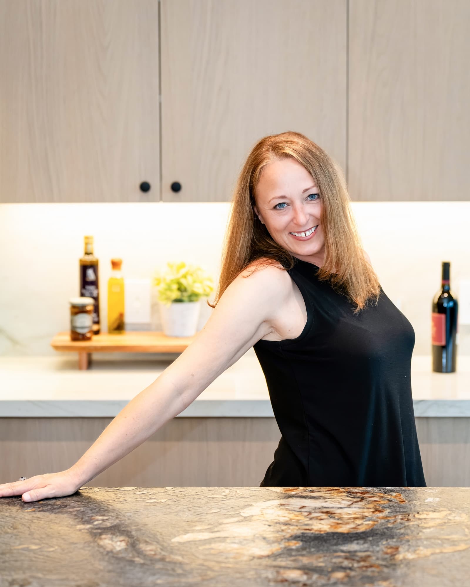 Agent leaning on a marble kitchen island