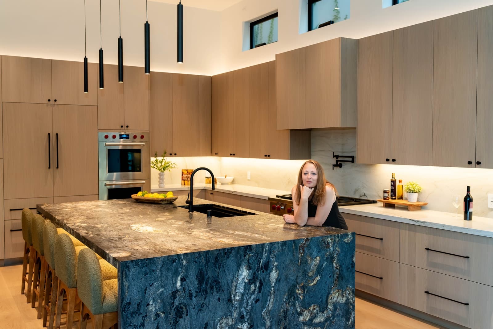 Agent at a marble island in a light-oak kitchen