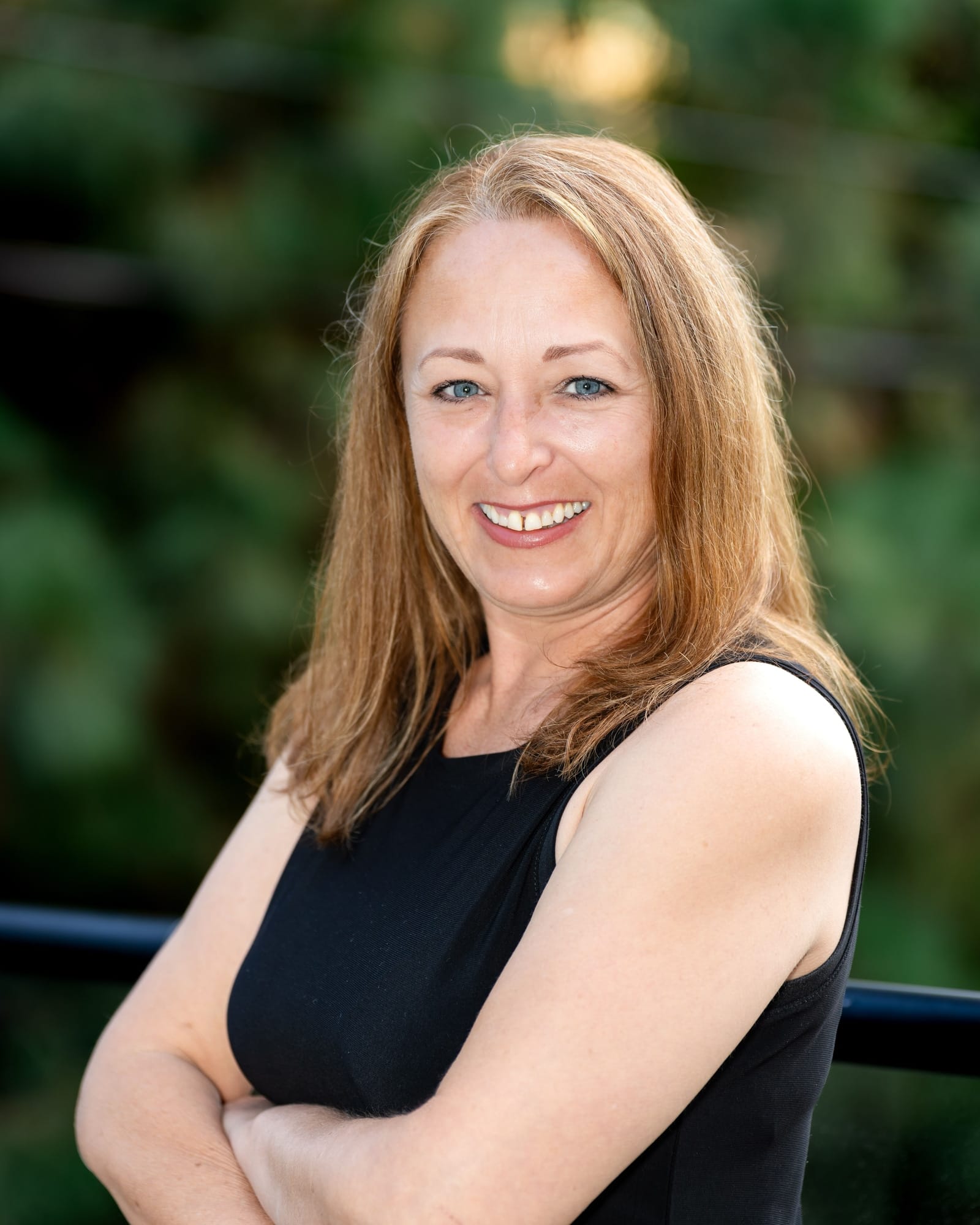 Agent smiling with arms crossed outdoors, from a Signature Standard branding session