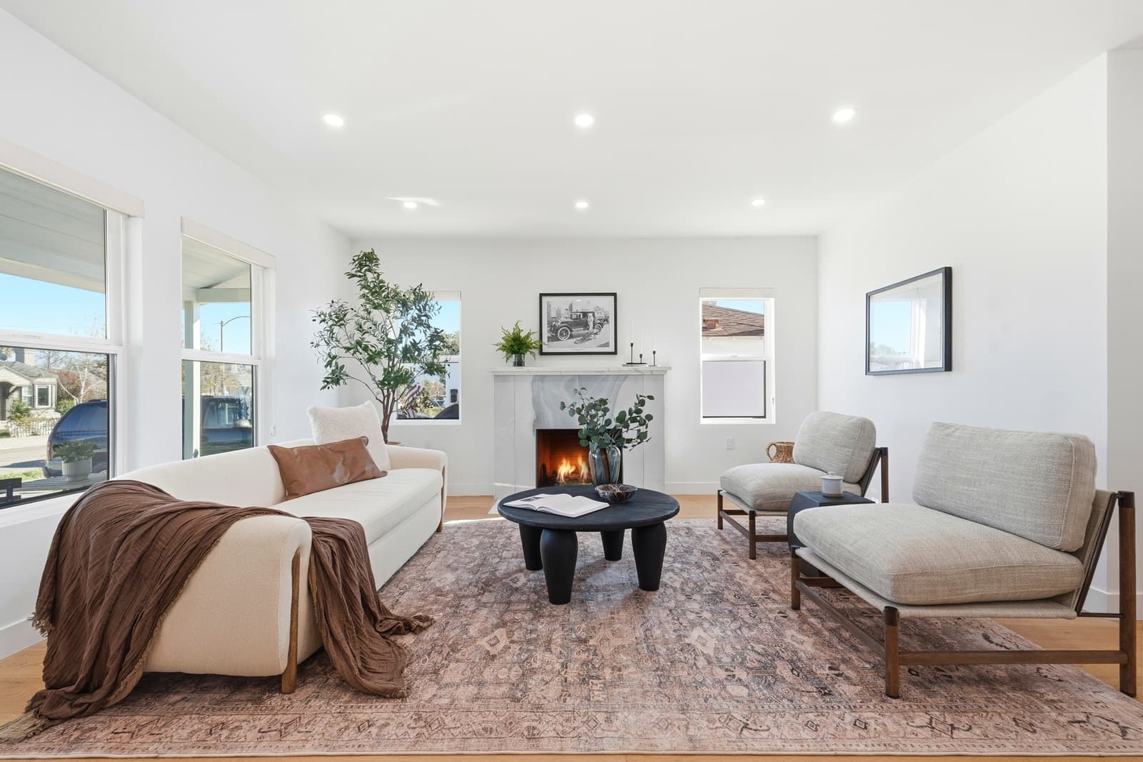 Bright white living room with the fireplace lit