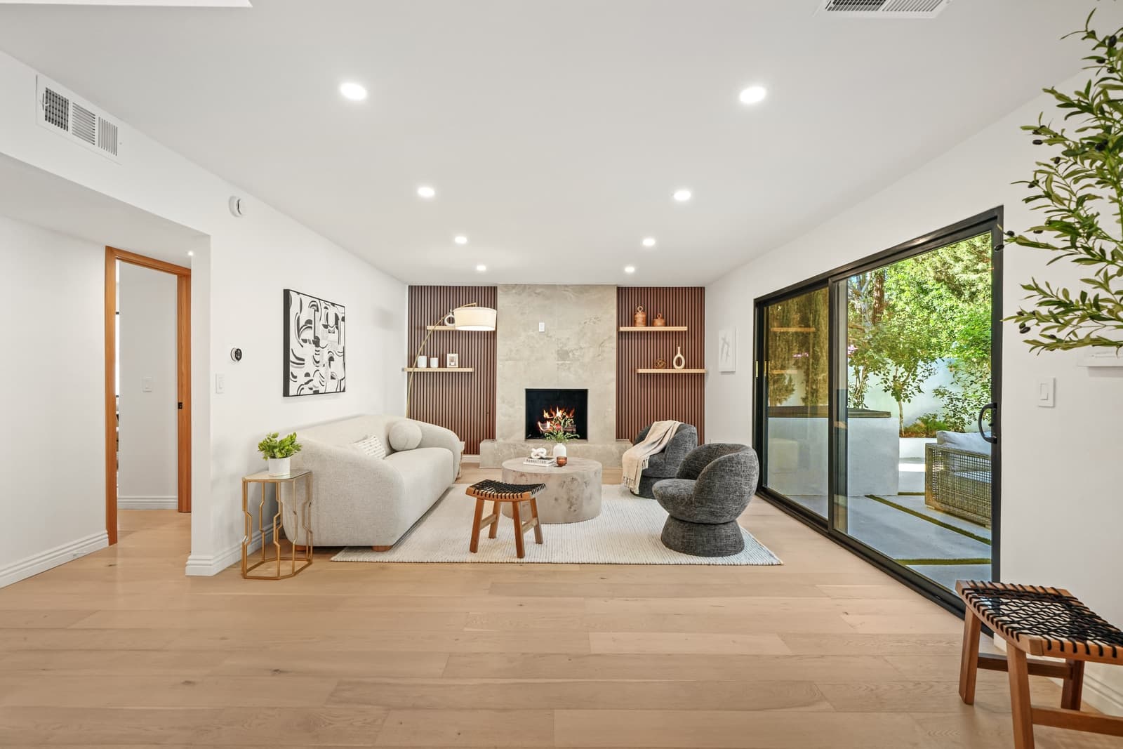 Fireplace lounge with charcoal chairs and oak built-ins