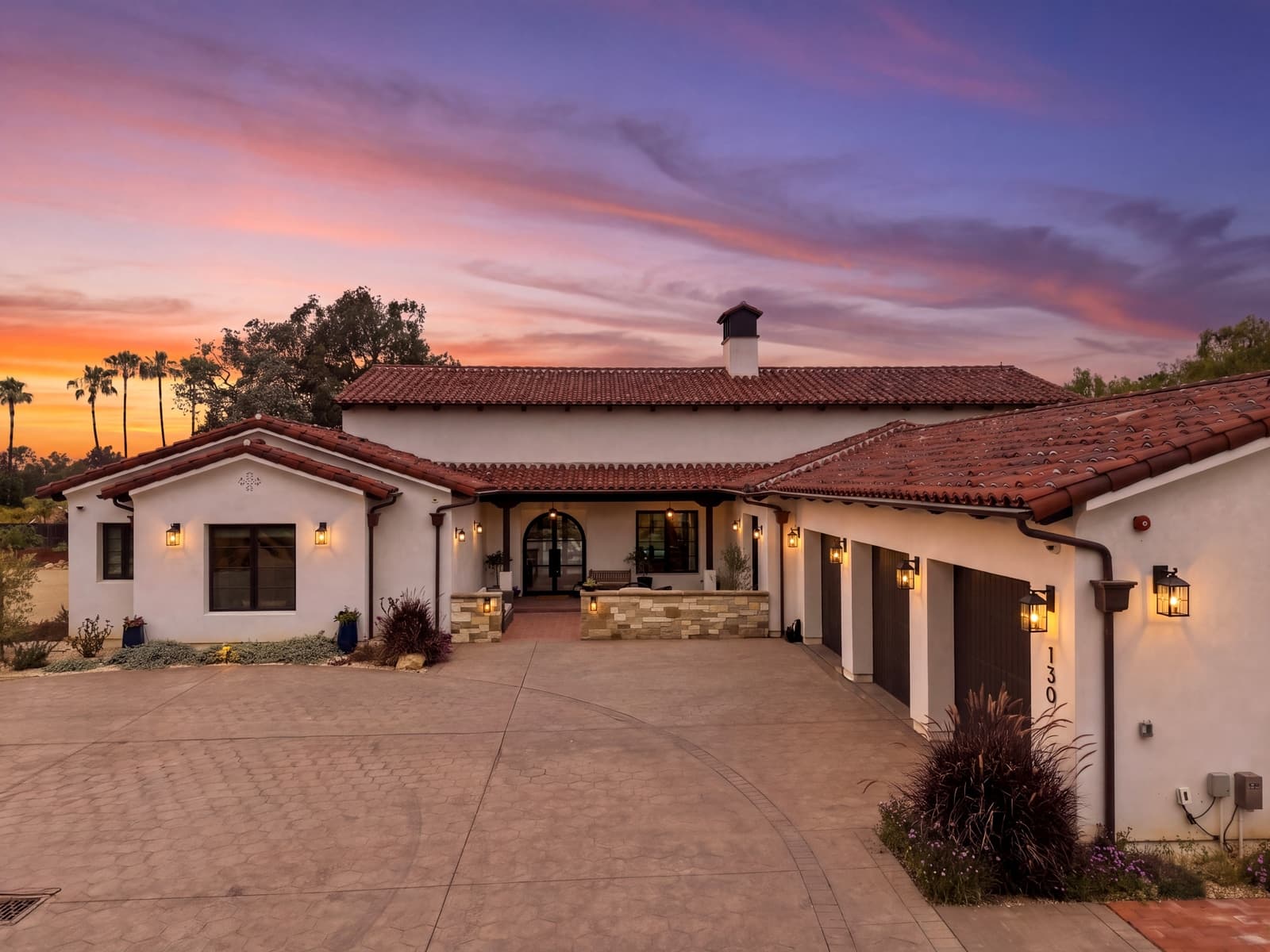Spanish ranch courtyard at twilight under a pink sky
