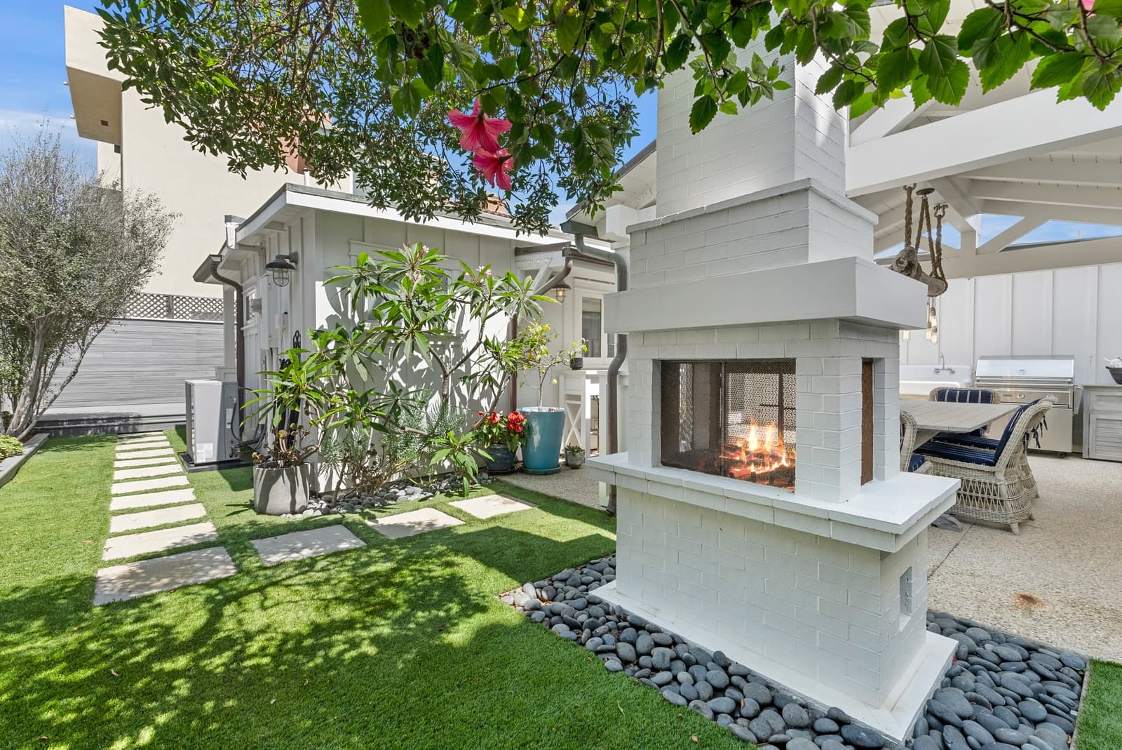 Courtyard with a white outdoor fireplace and lawn