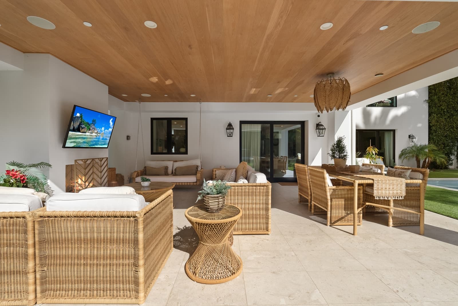 Covered patio with rattan seating and a wood ceiling