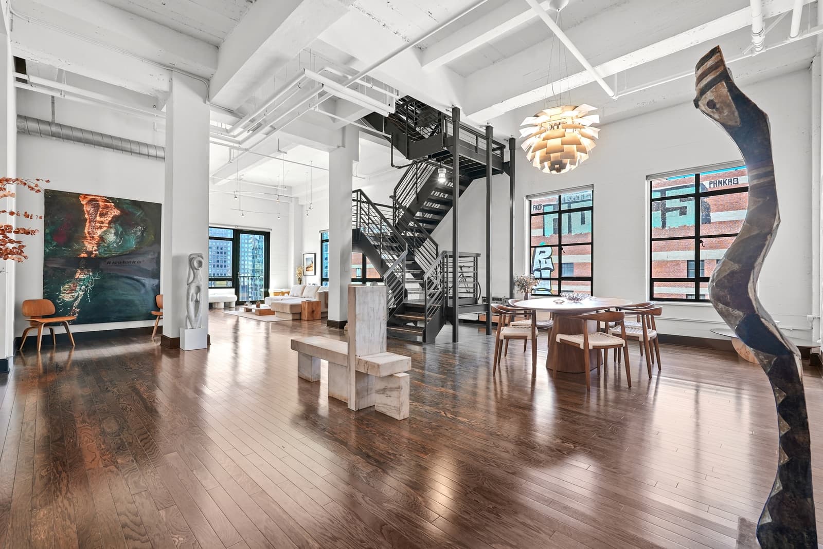 Double-height loft with a black stair and abstract art
