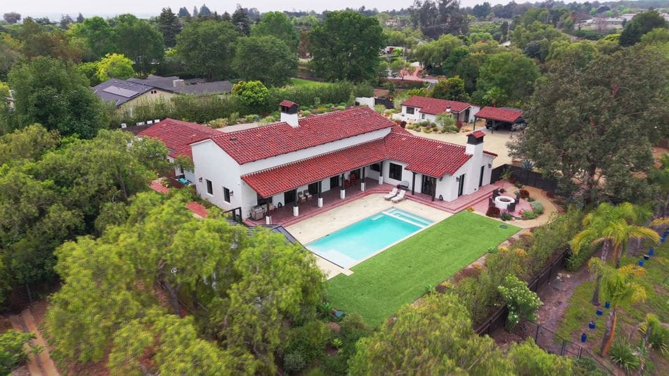 Drone over a Spanish ranch in Camarillo, the pool and lawn below, from its listing film