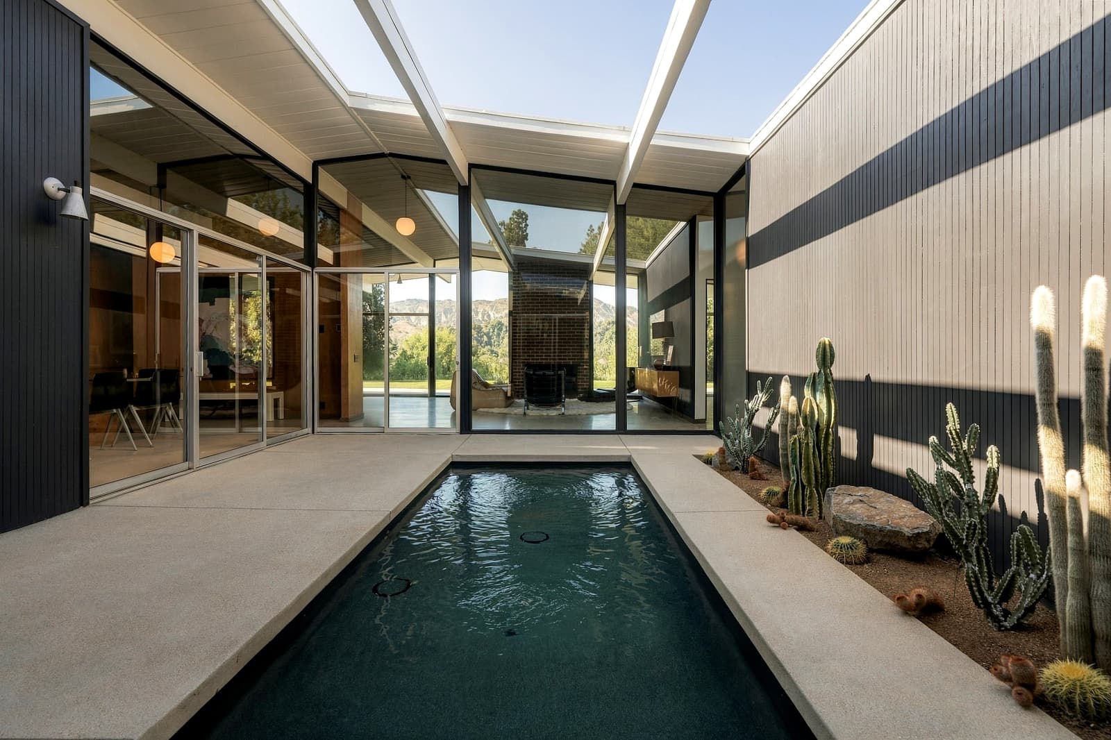 Lap pool down the center of an open atrium, post-and-beam roof overhead