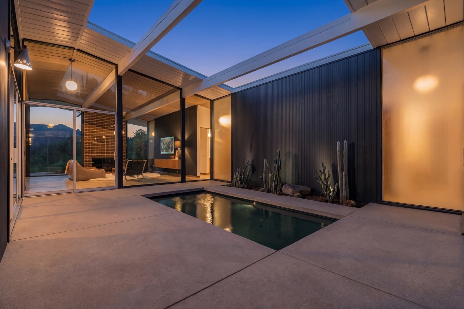 Atrium pool at twilight, post-and-beam roof and lit glass walls