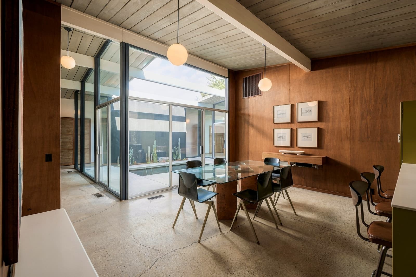 Dining table beside the glass wall onto the atrium pool