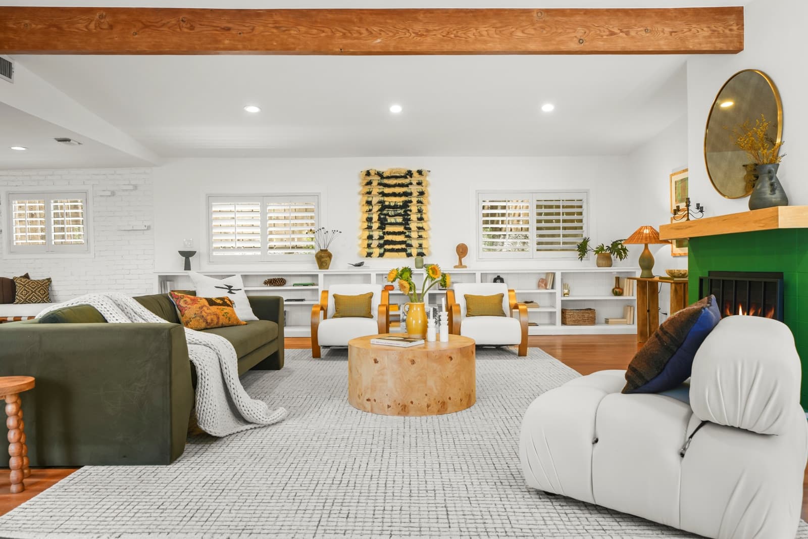 Living room with a green fireplace and a curved sofa