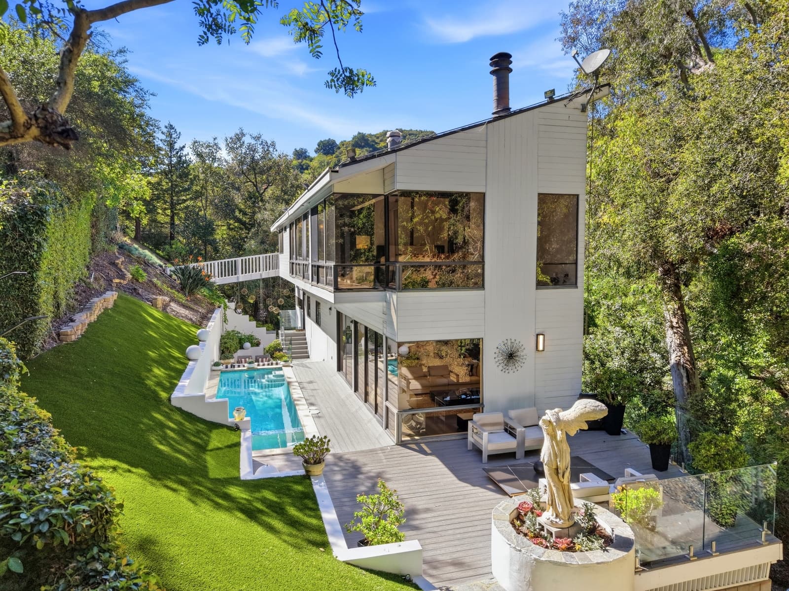 Hillside home with a pool, seen from above through the trees