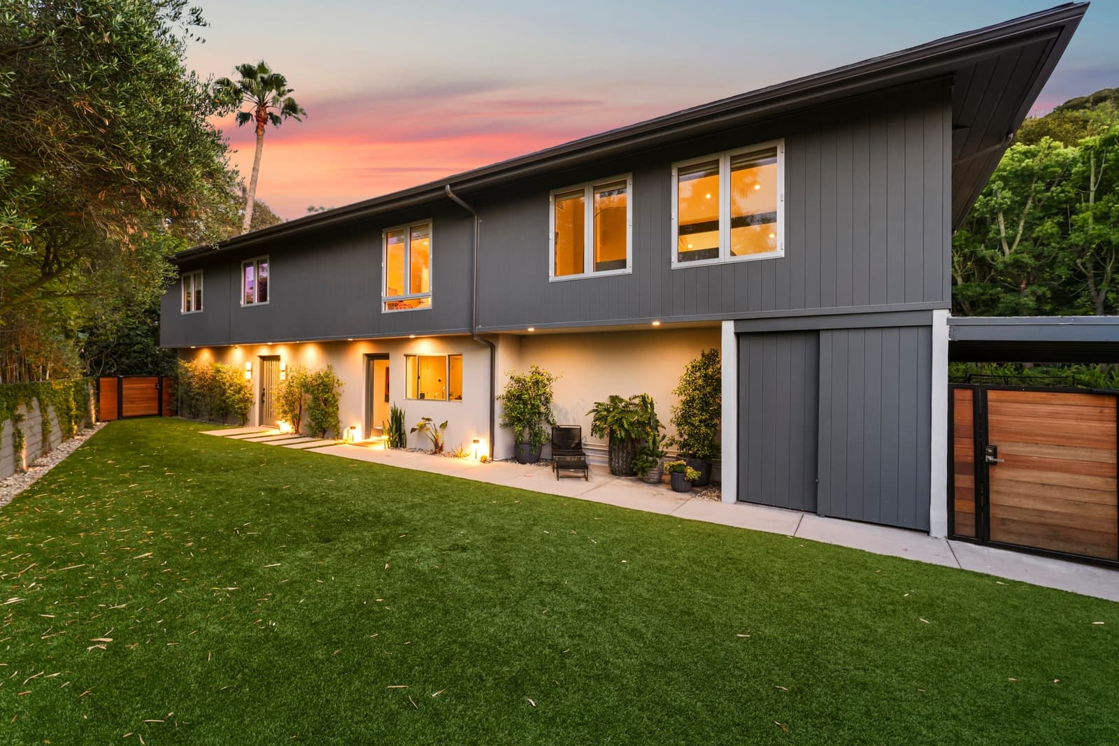 Charcoal modern front elevation at twilight with a lit lawn path