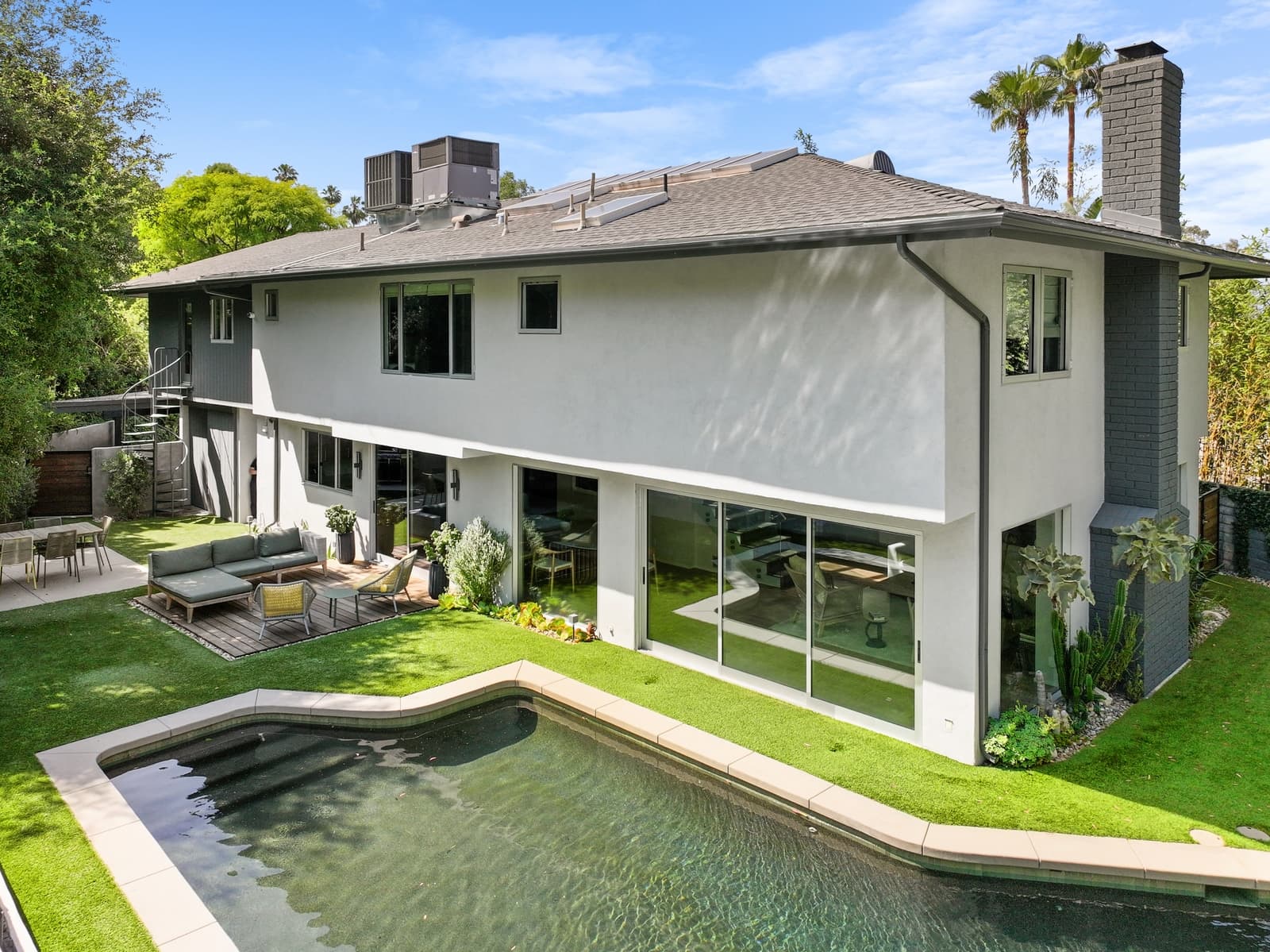 Drone view of a modern home's rear yard, pool and lawn, Hollywood Hills