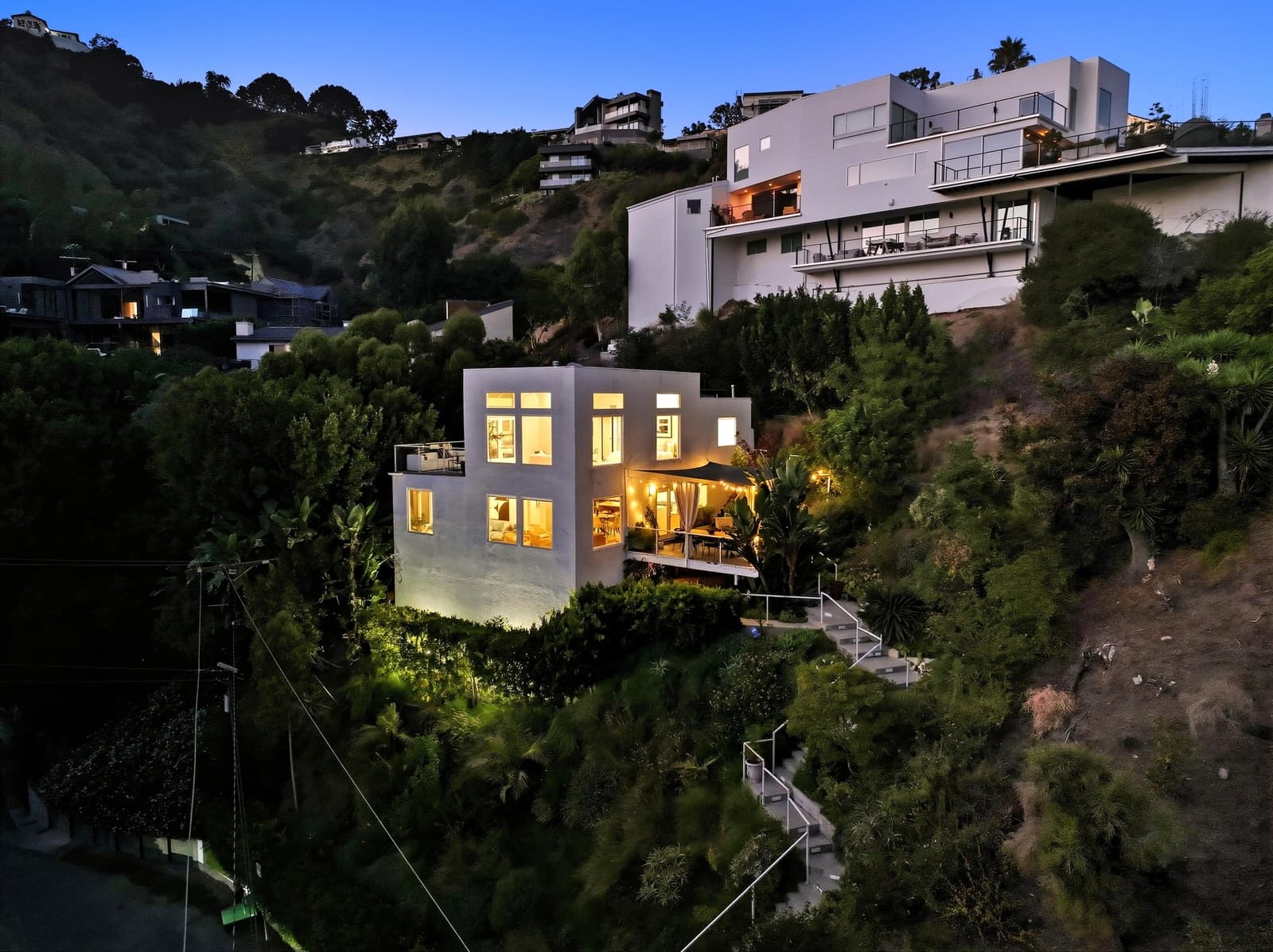 Drone twilight over a white modern perched in the Hollywood Hills