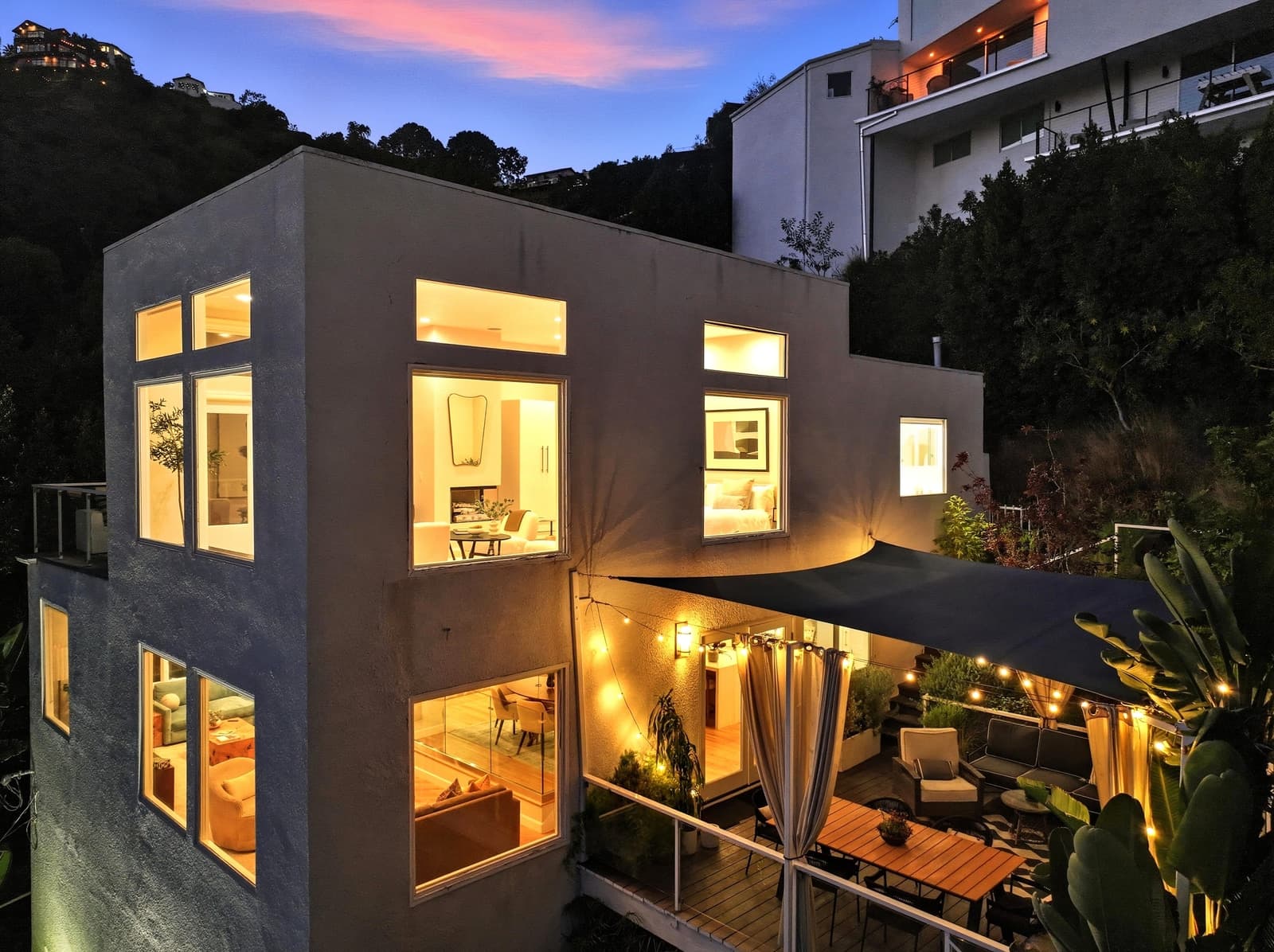 Hollywood Hills modern at twilight, every window lit
