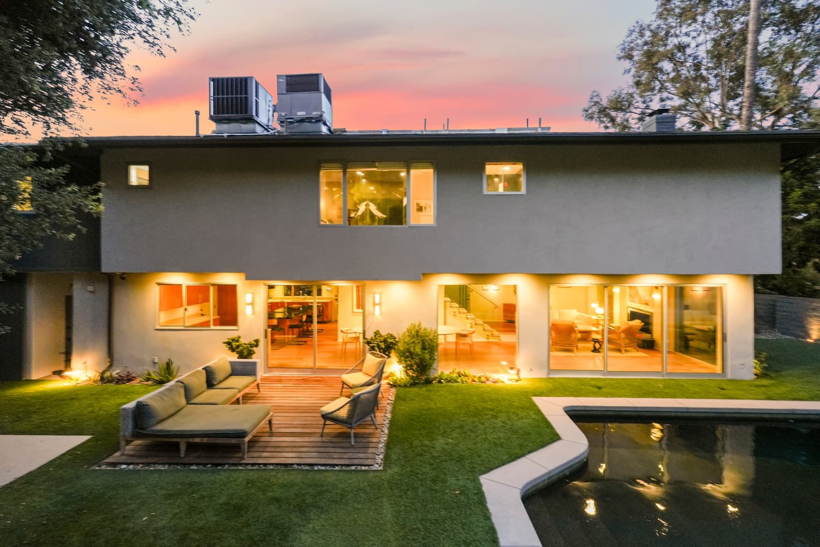 Rear elevation at twilight with a deck sofa and lit interiors, Hollywood Hills