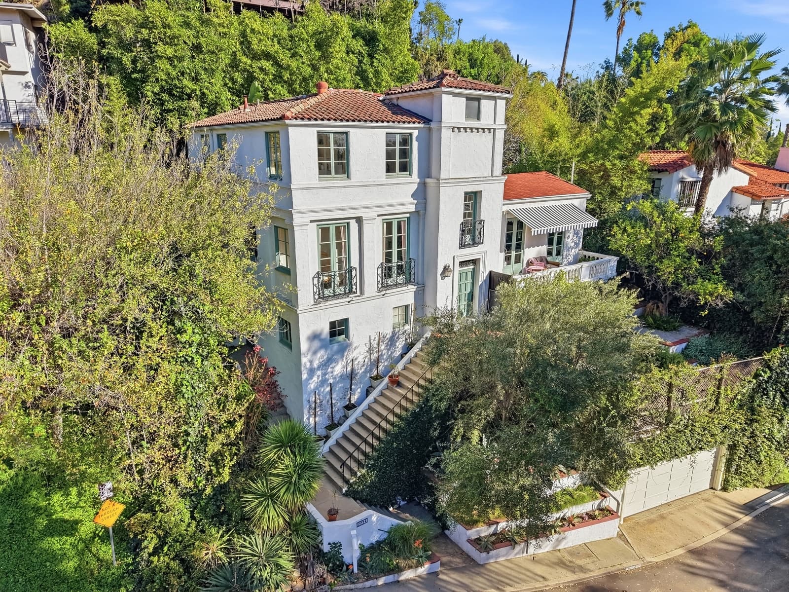 A Spanish hillside home in the Hollywood Hills, stairs to the entry.