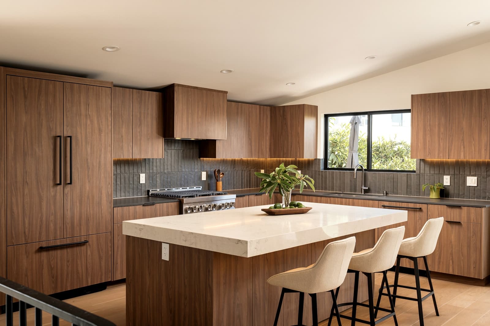 Walnut kitchen with a white stone island and slate tile backsplash