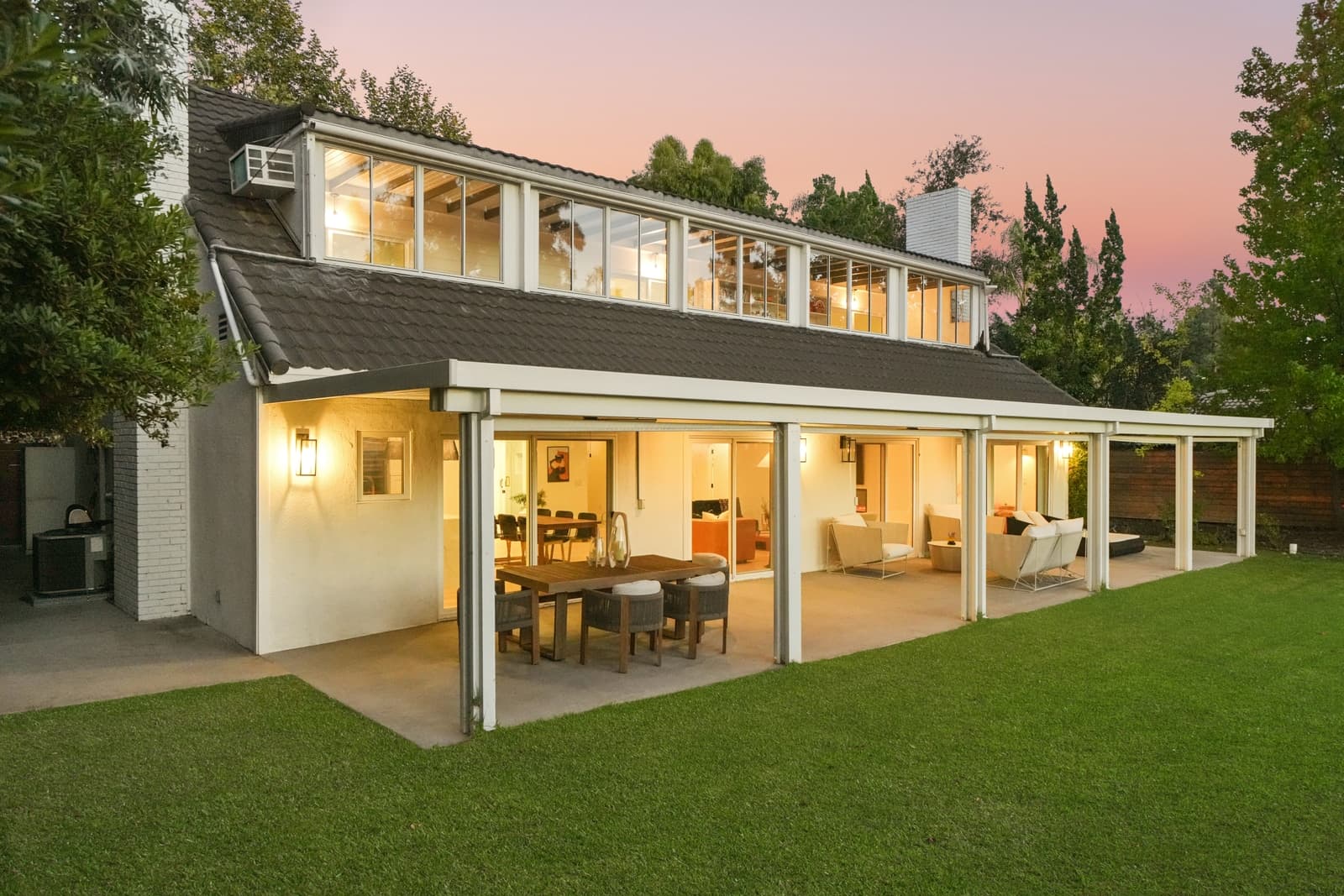 La Cañada modern farmhouse at twilight, patio dining lit