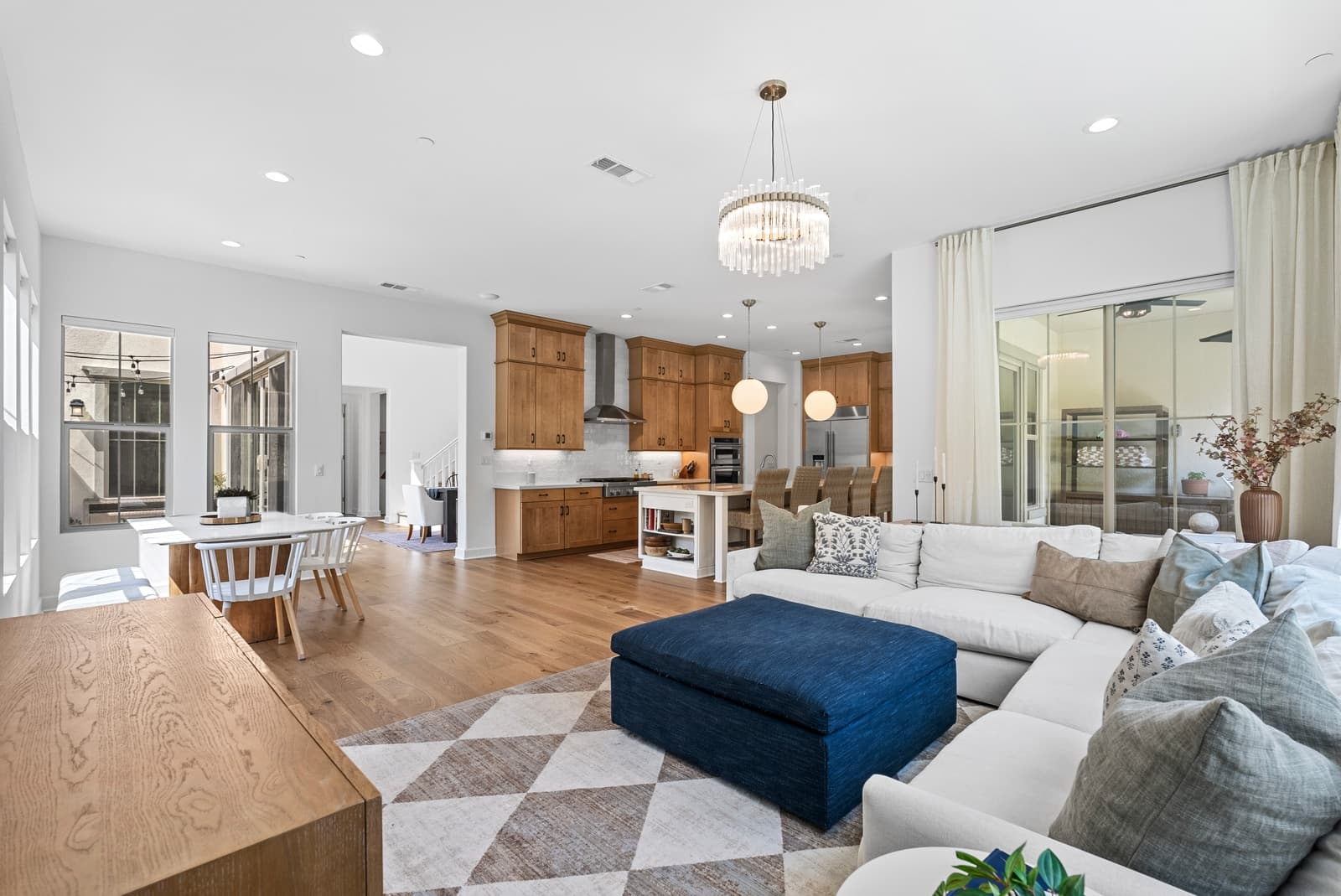 Living room with a checkered rug, oak kitchen beyond