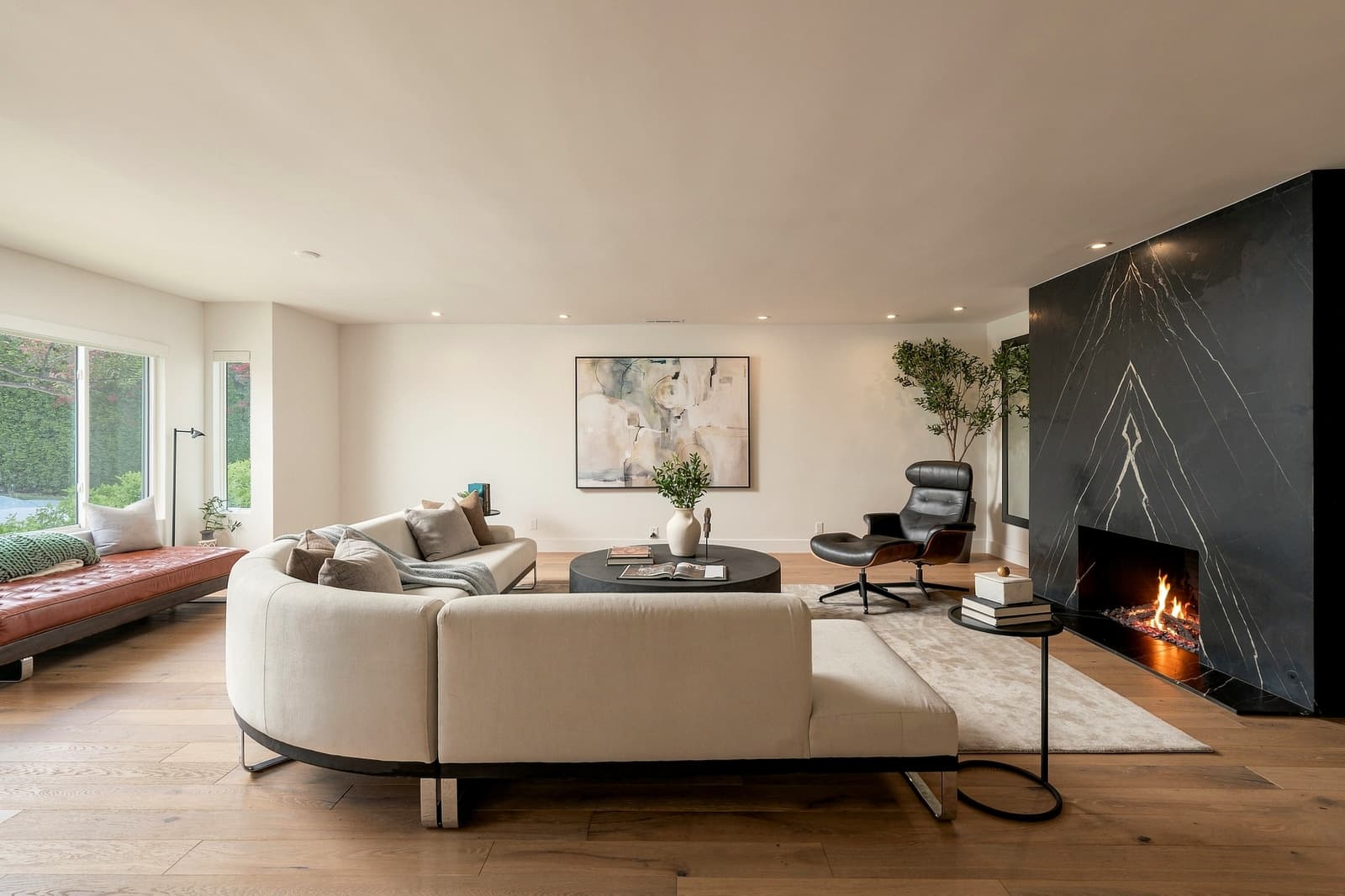 Living room with a black marble fireplace and a curved sectional, Signature finish