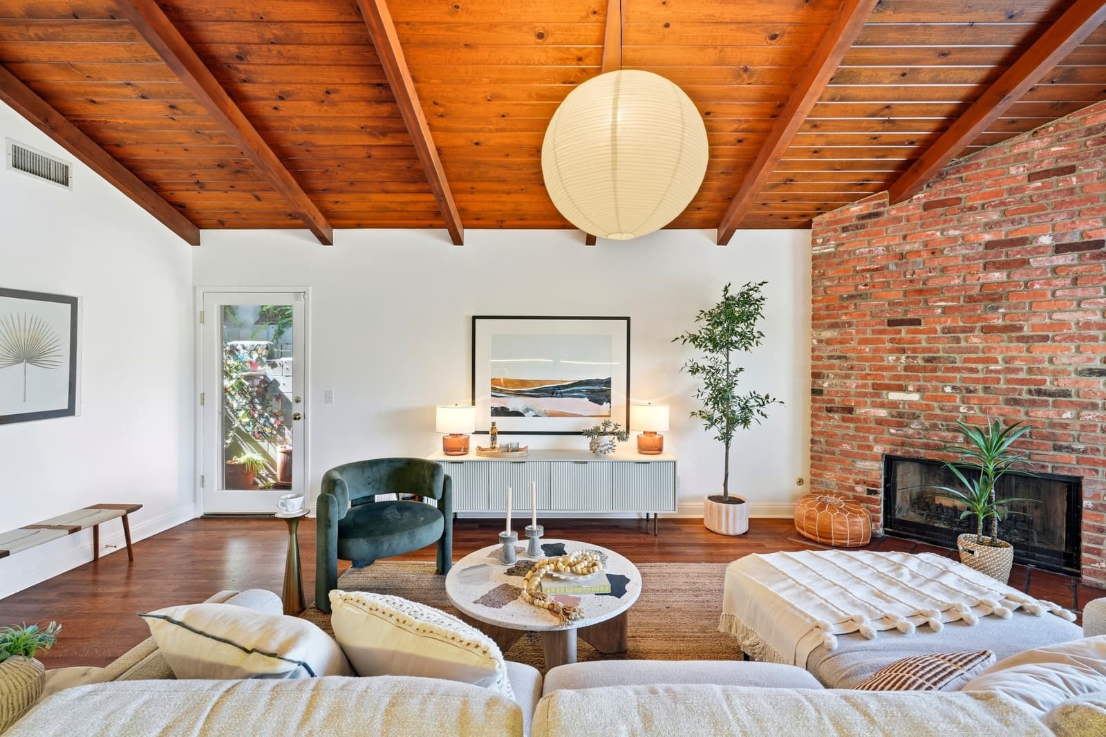 Living room with a wood beam ceiling and brick fireplace