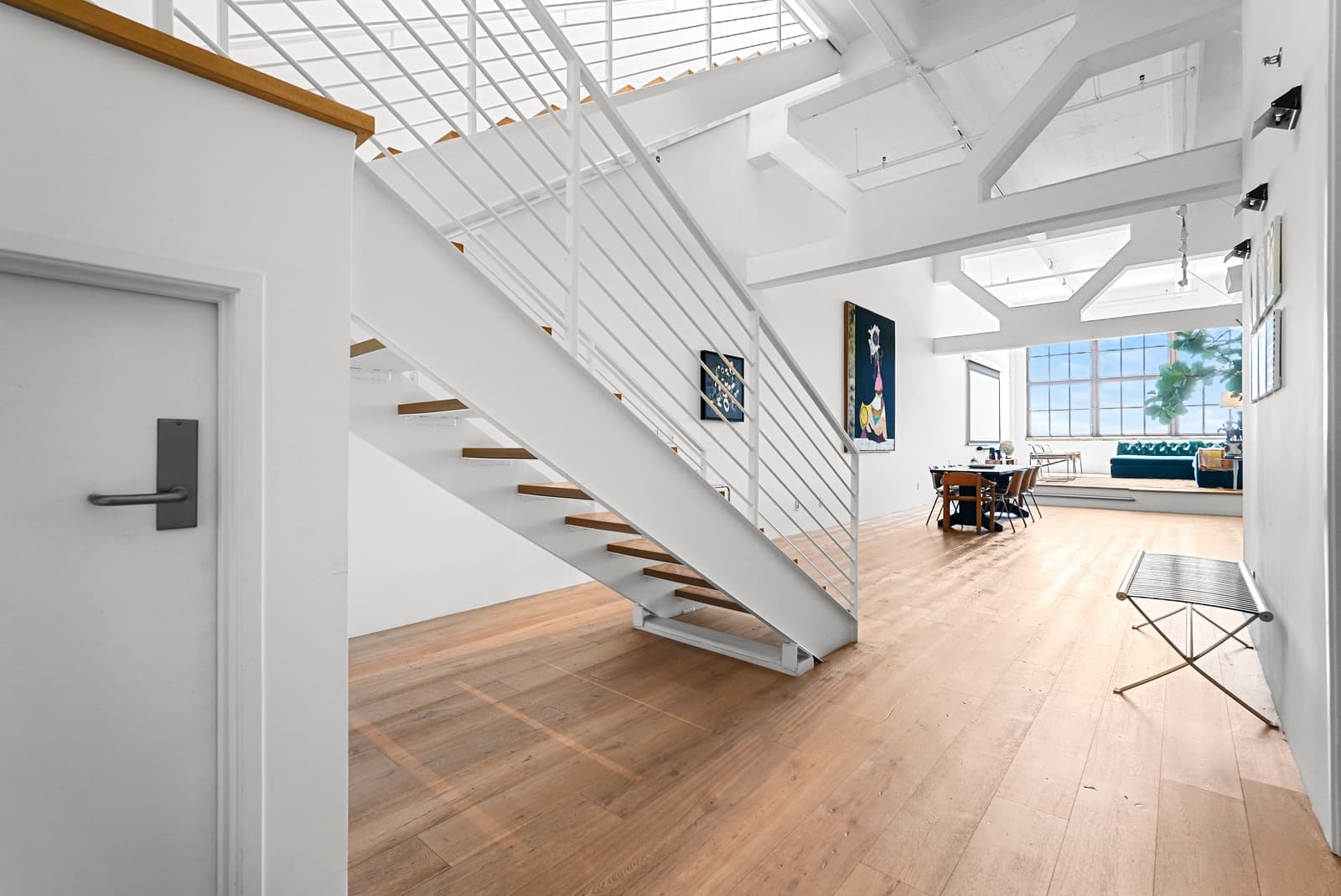 Open stair under a skylight in a white loft