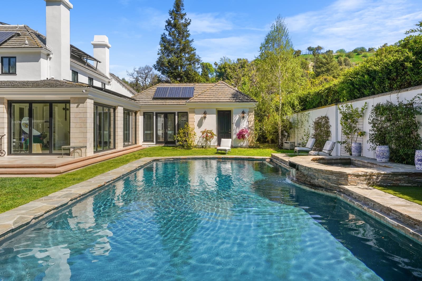 Pool and lawn beside a white pergola
