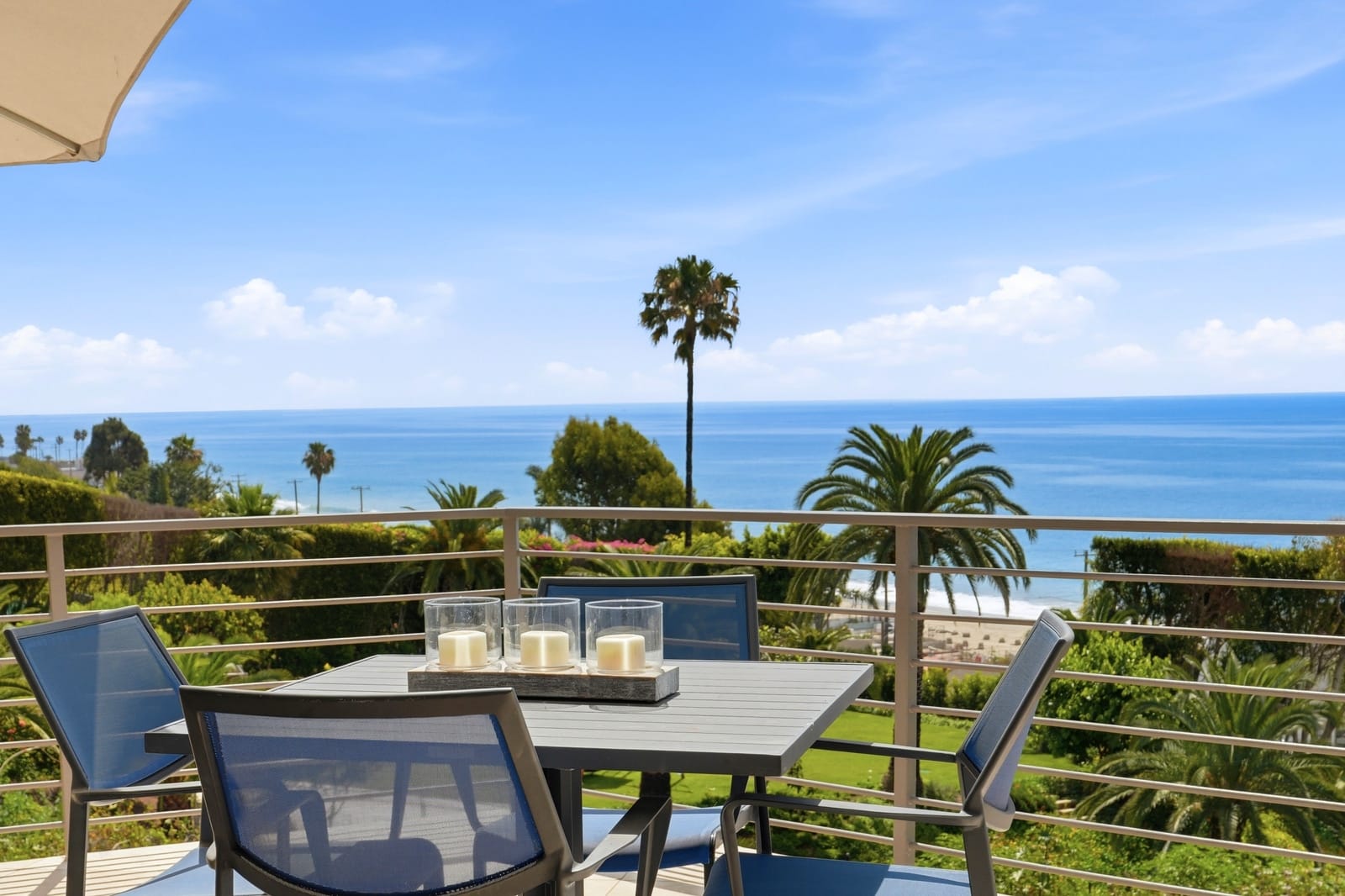 Deck dining table above the ocean and palms