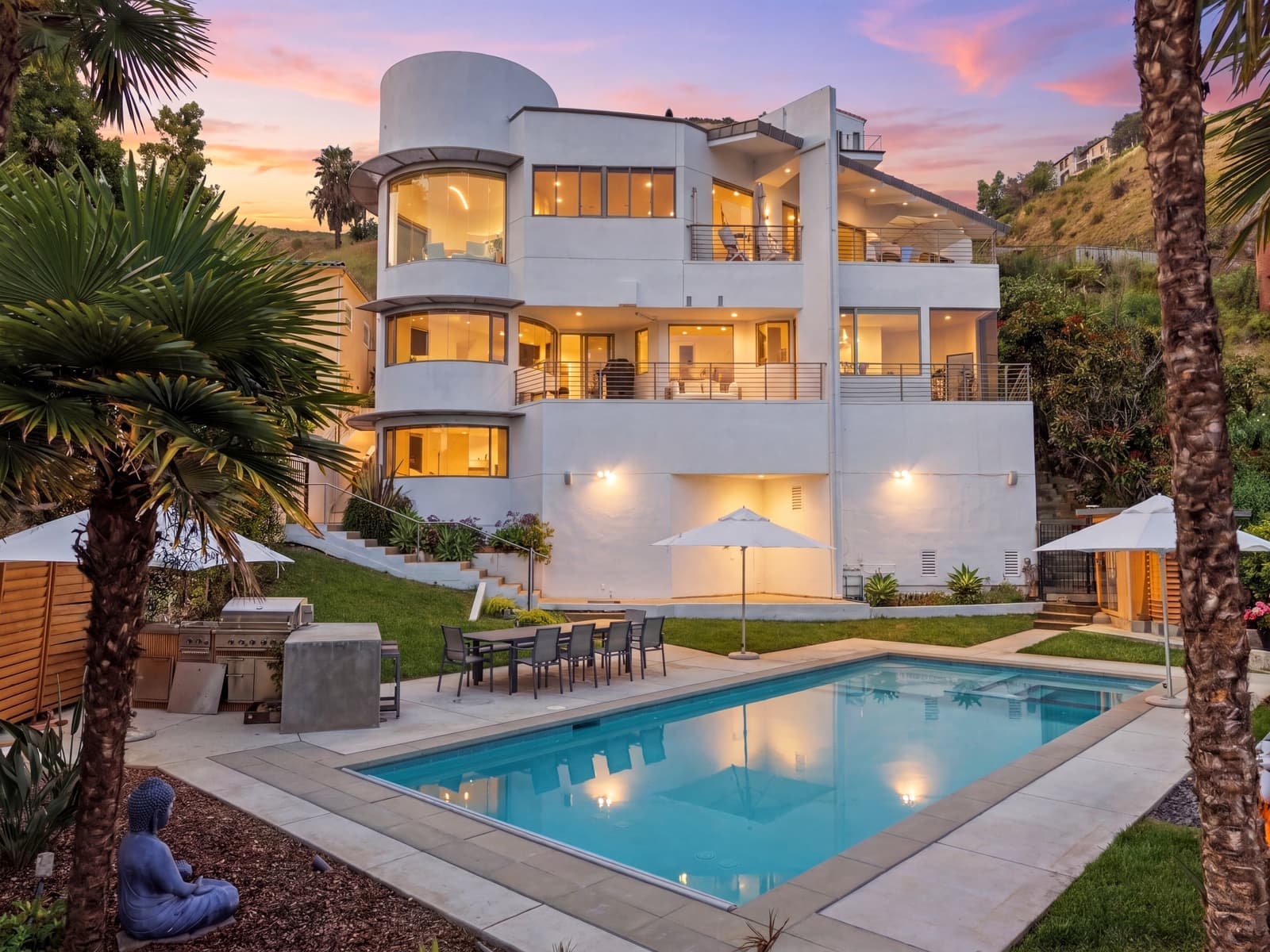 Three-story Malibu home at twilight above the pool