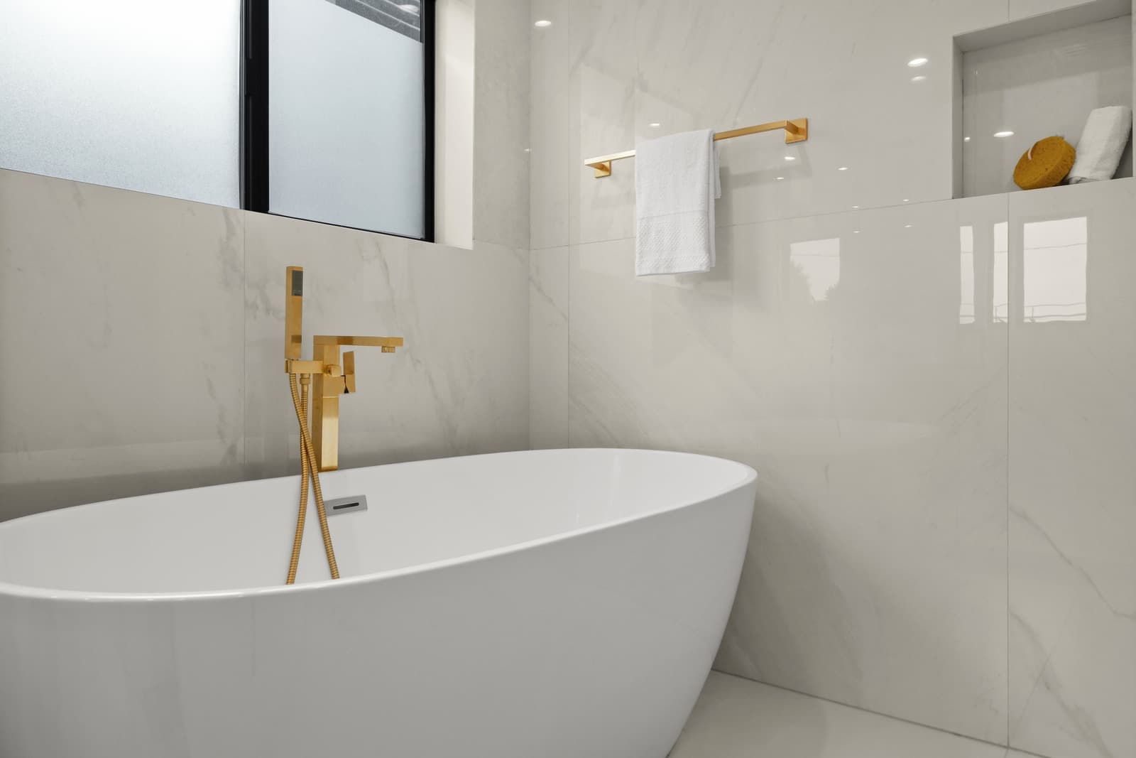 Marble bath with a gold floor-mounted tub filler