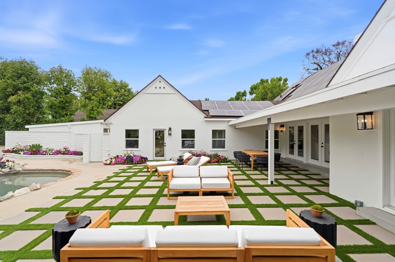 Modern farmhouse backyard with a pool and checkerboard turf pavers
