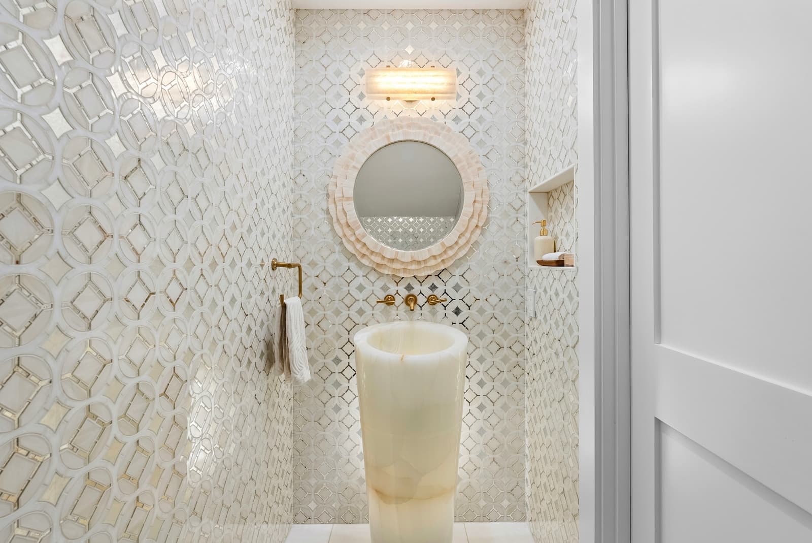 A powder room with an onyx pedestal basin.