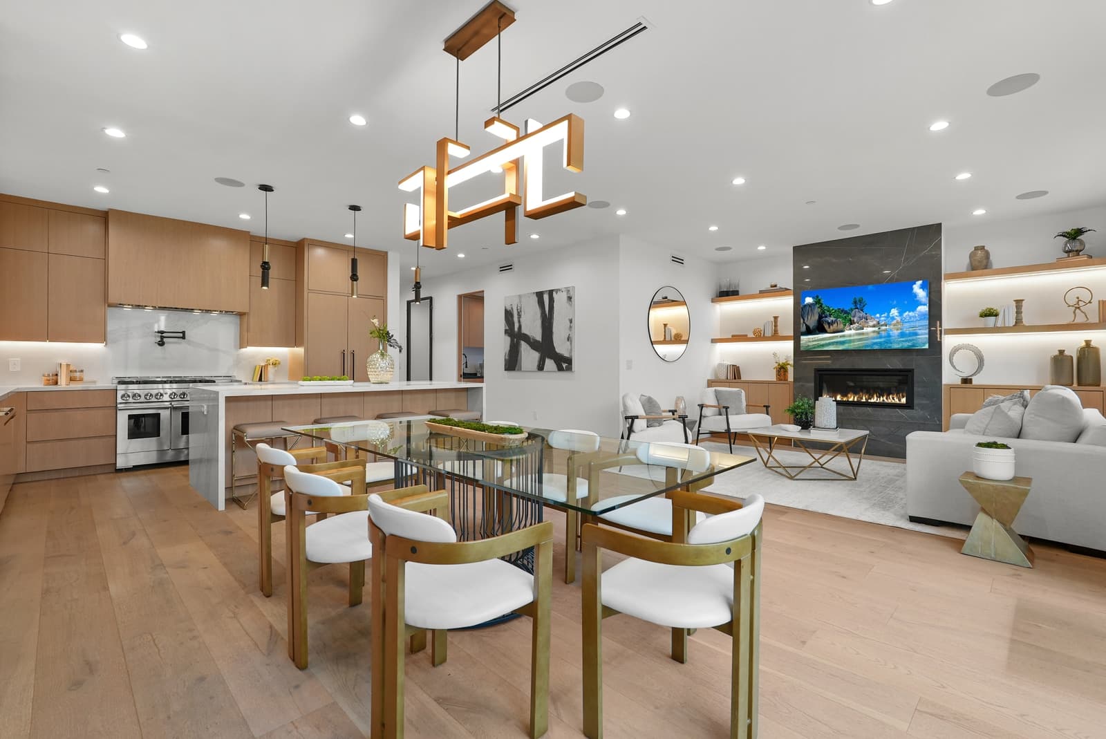 Open dining and kitchen under a pendant, oak cabinetry