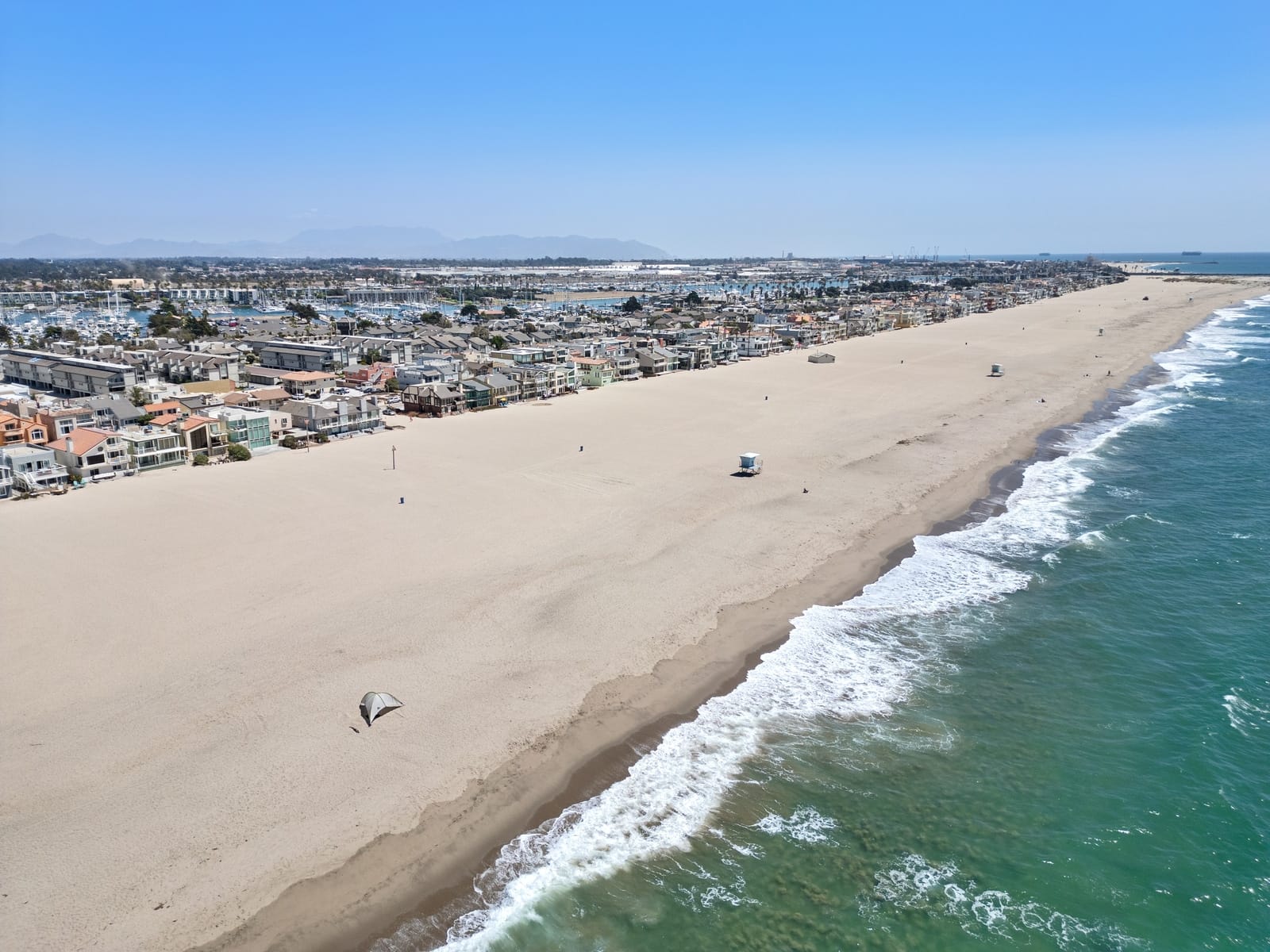 Drone along the surf line toward the marina