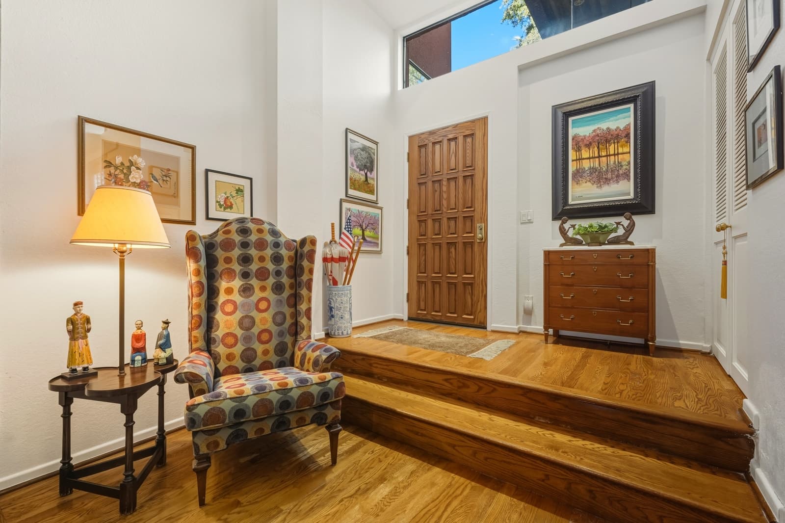 Traditional foyer with a wood door and antique chair, photographed by VVT in Pasadena