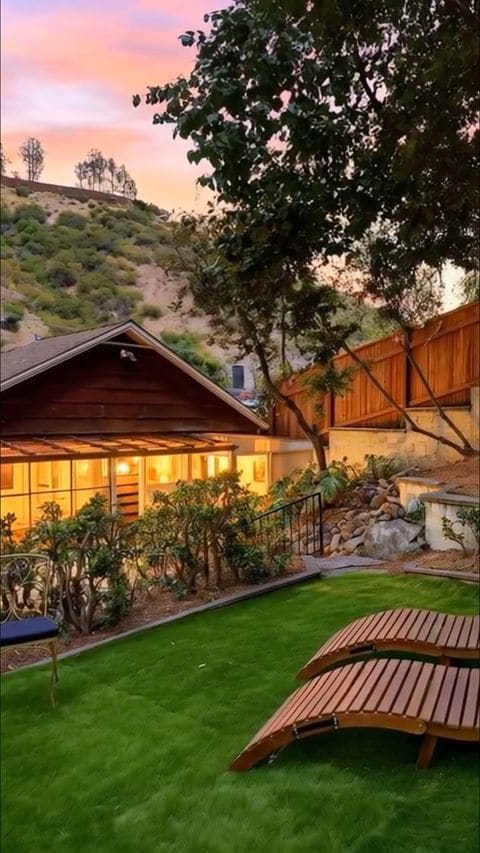 Craftsman cabin at dusk with loungers on the lawn, from a Landon Realty Group listing teaser