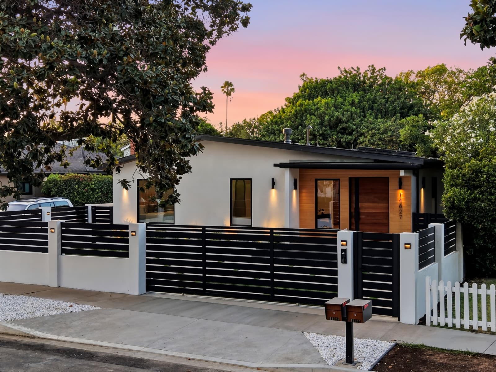 Modern single-story at twilight behind a horizontal-slat fence, Sherman Oaks