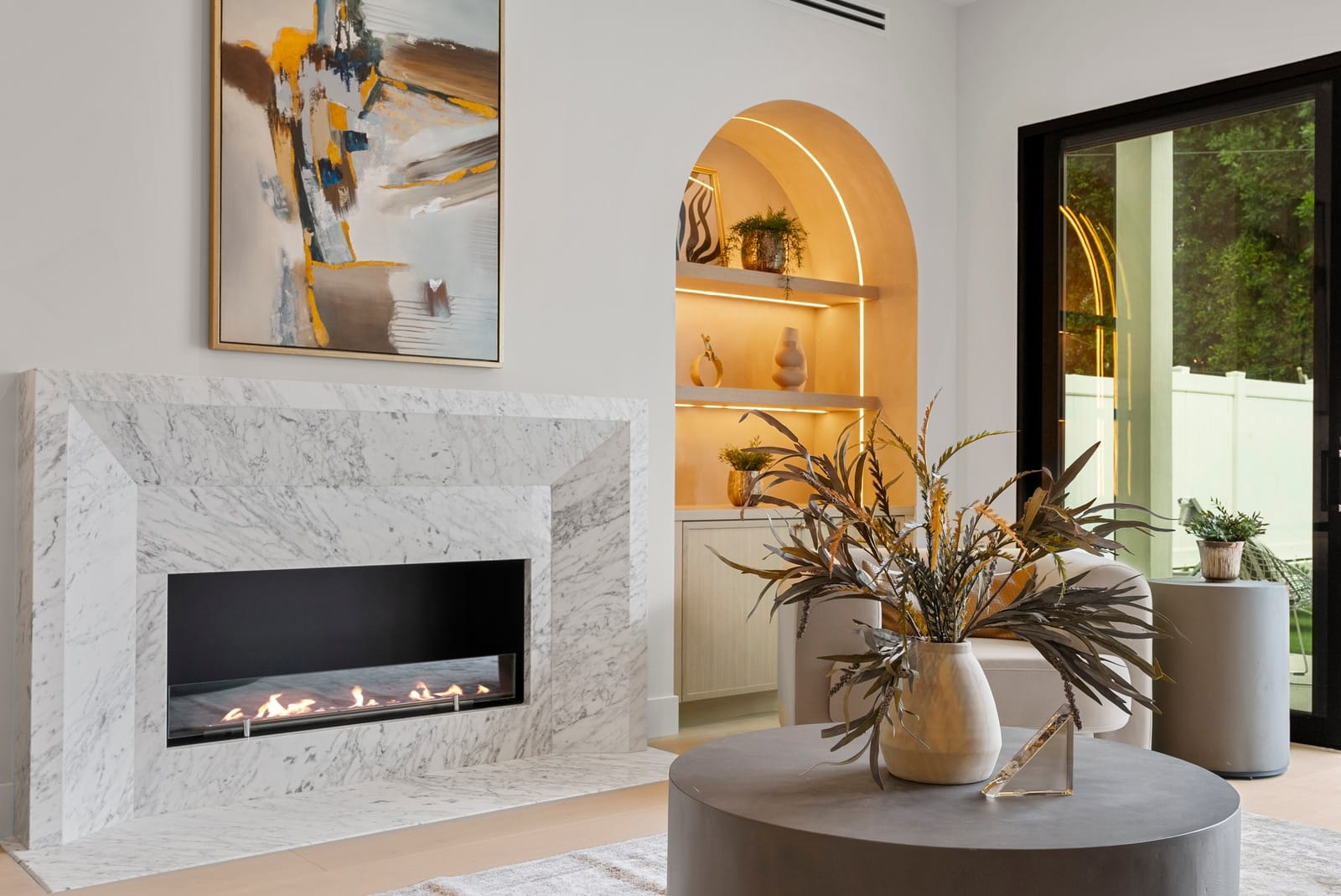 Marble fireplace between lit arched niches, seen straight on