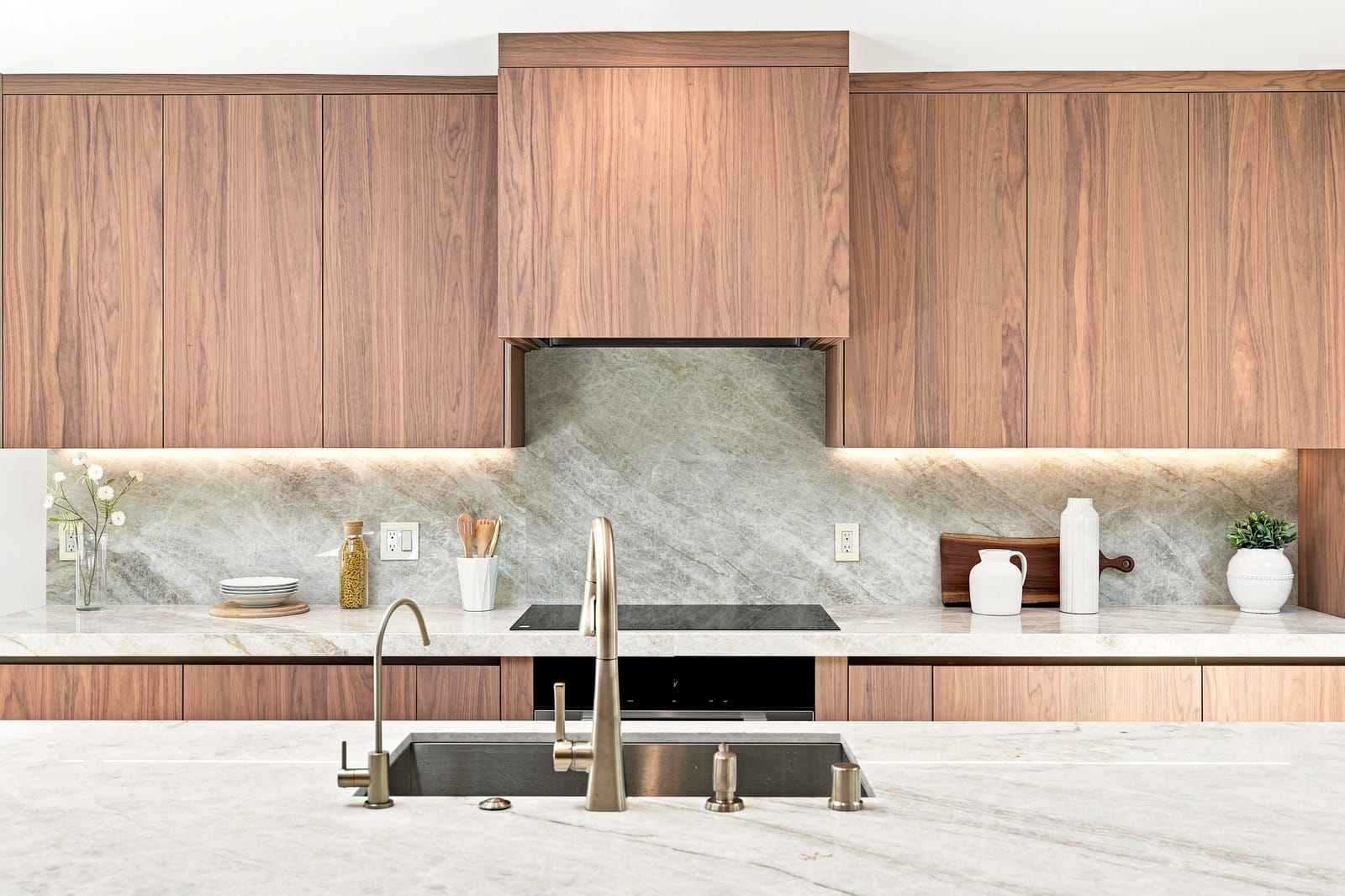 Walnut kitchen with a stone backsplash, seen straight on